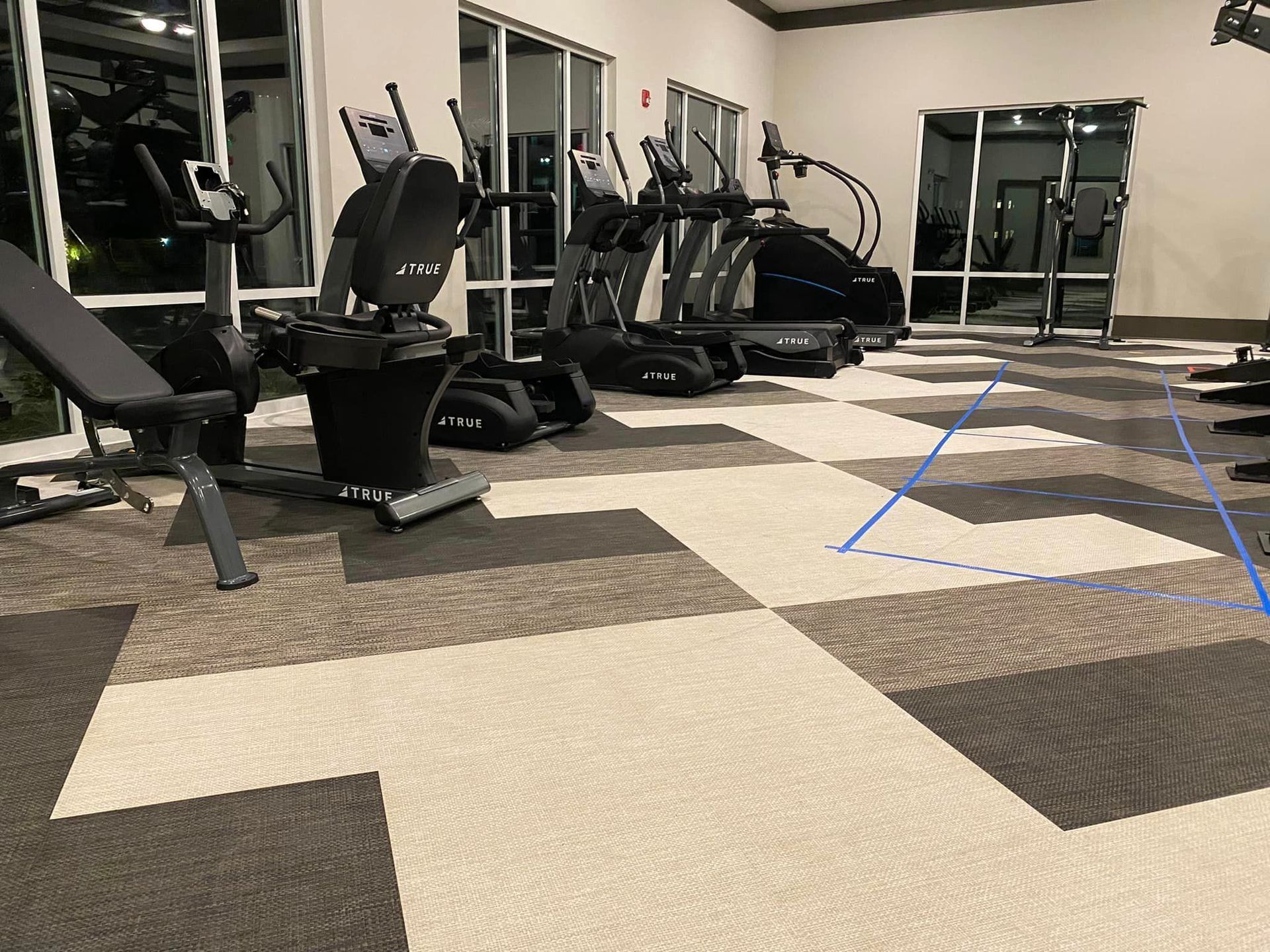 A gym with a lot of exercise equipment on the floor.
