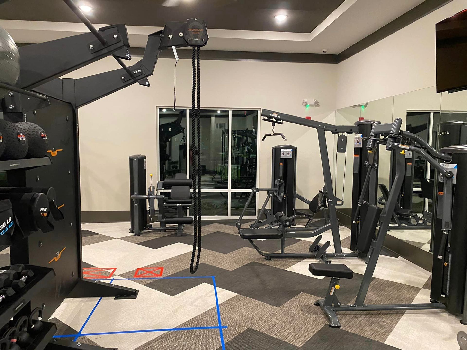 A gym with a lot of equipment and a large mirror.