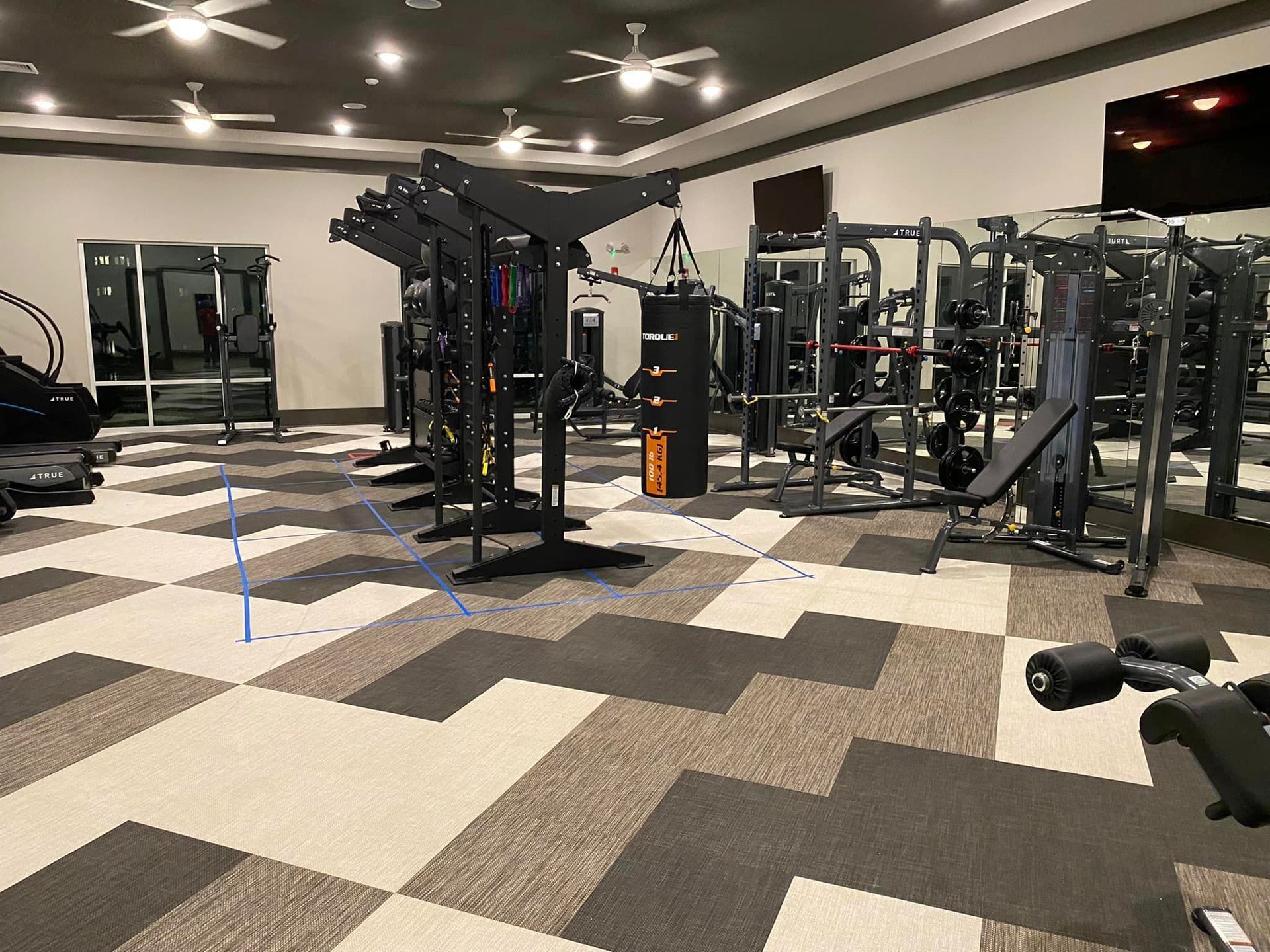 A large gym filled with lots of exercise equipment.