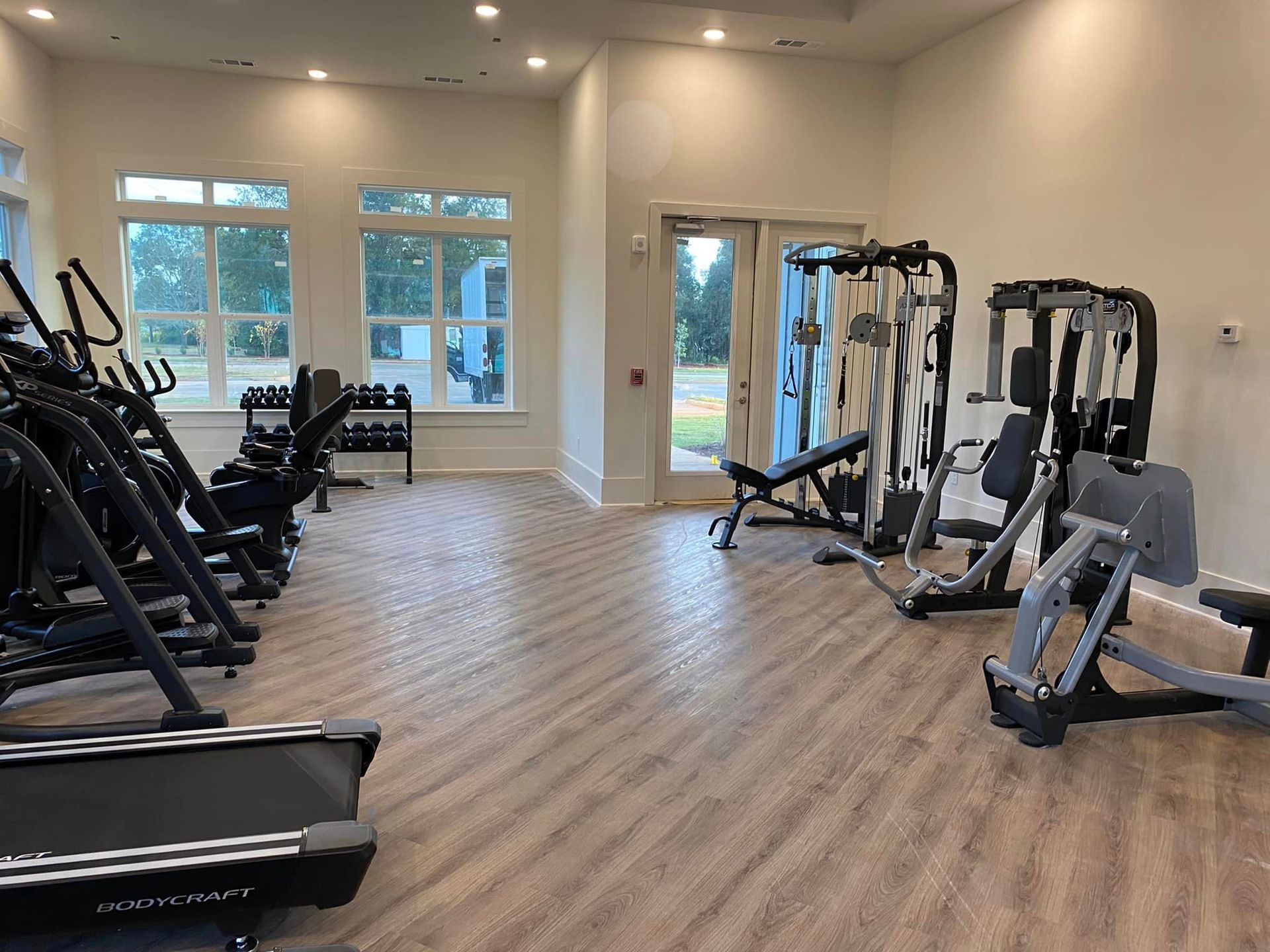 A large gym filled with lots of exercise equipment.