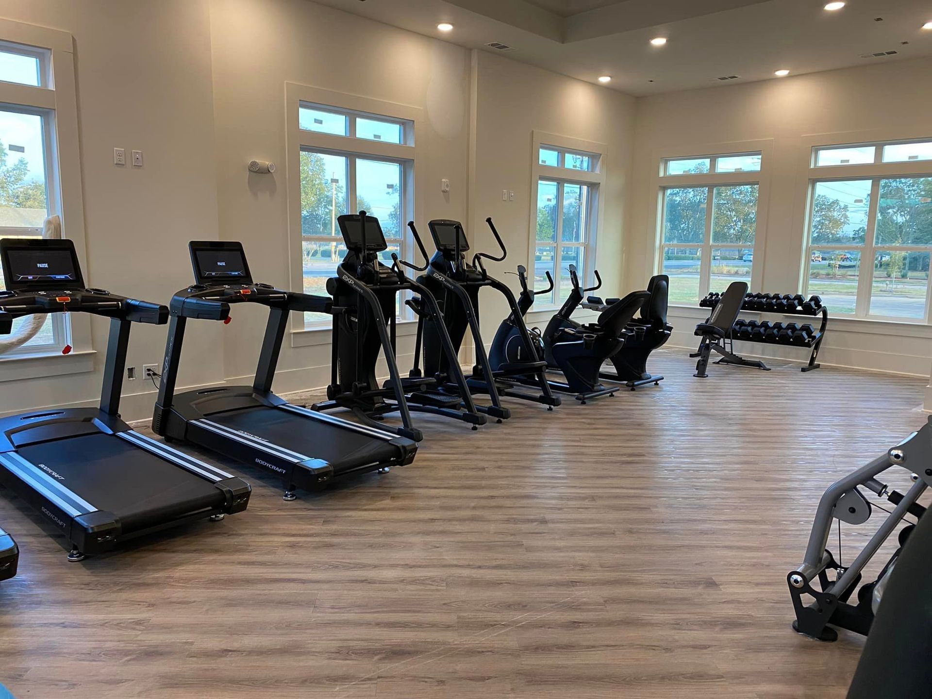 A gym filled with treadmills , ellipticals , and other exercise equipment.