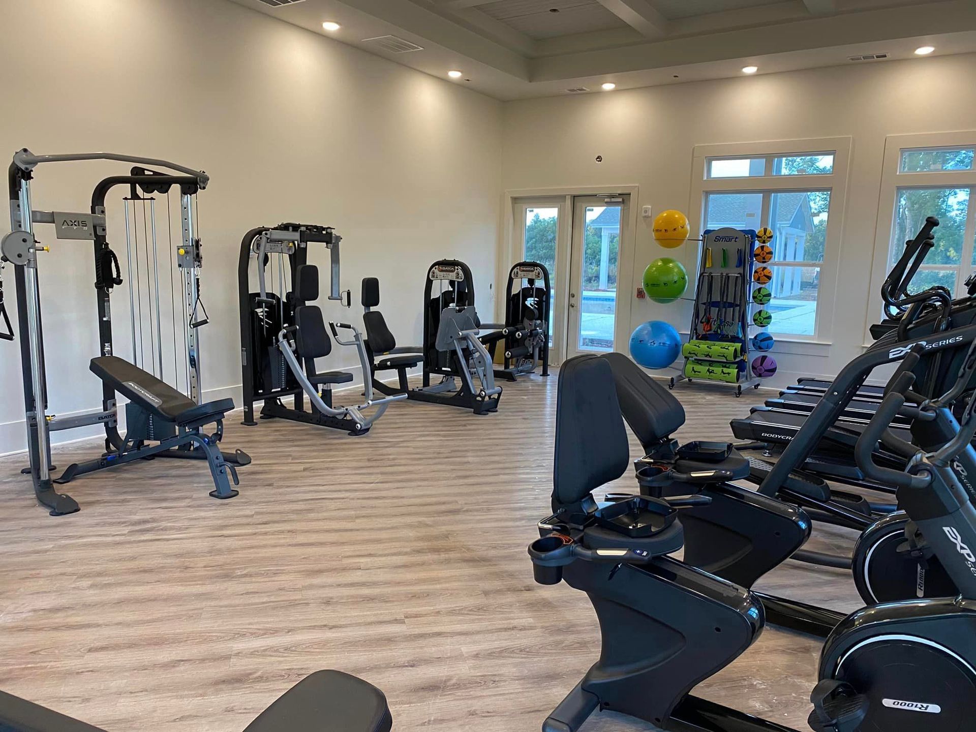 A large gym filled with lots of exercise equipment.