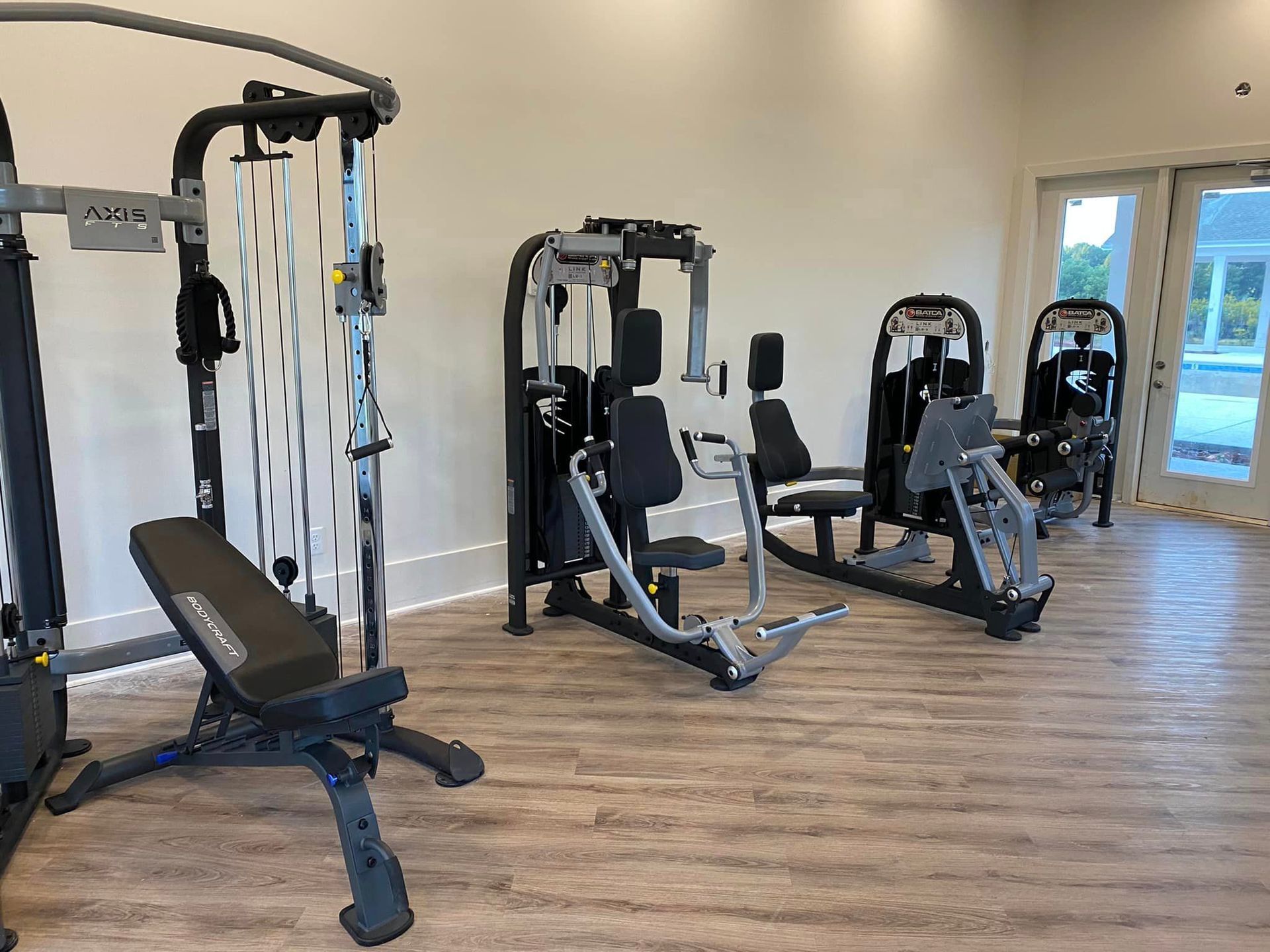 A gym filled with lots of exercise equipment and a bench.