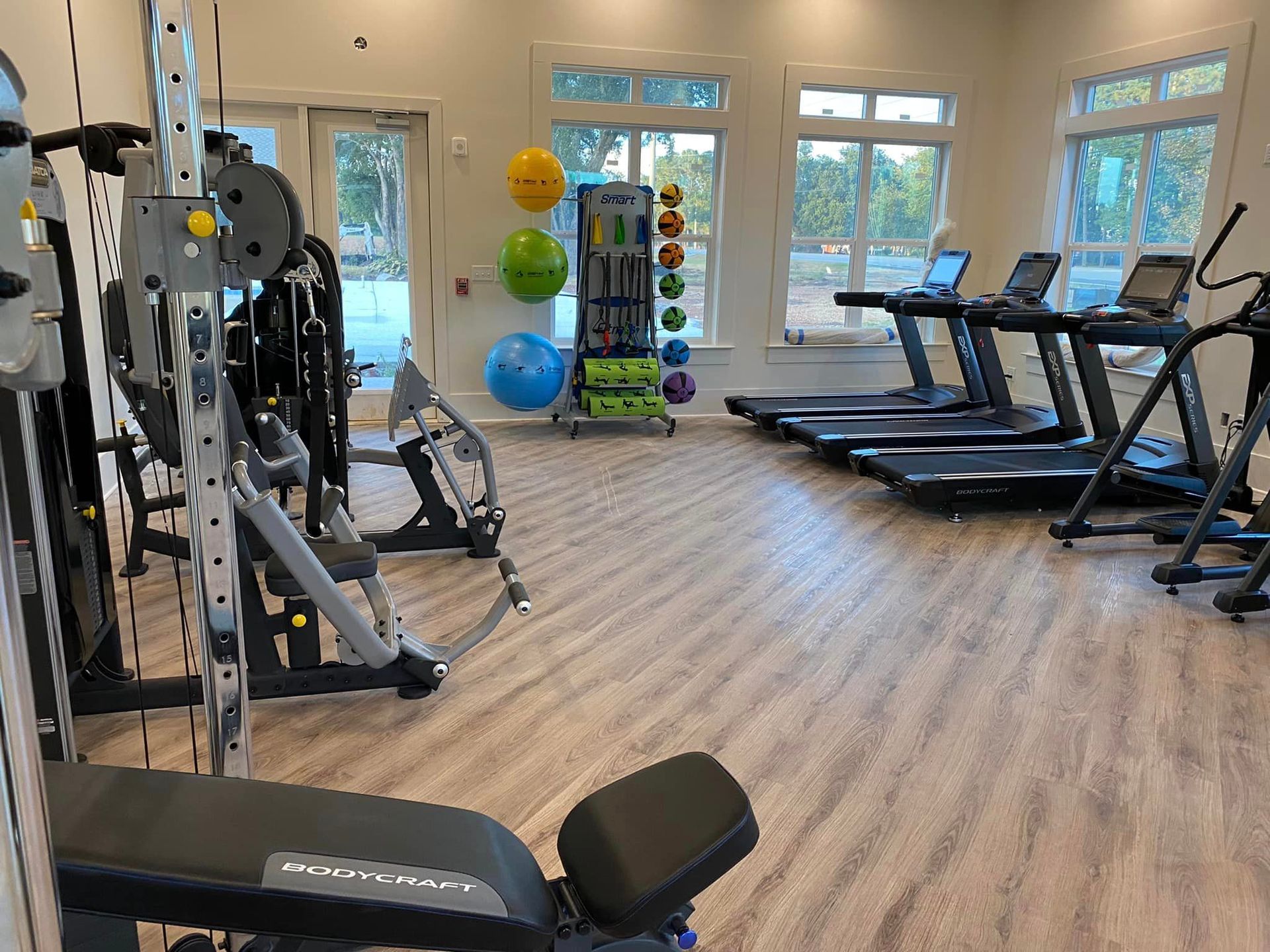 A large gym filled with lots of exercise equipment.