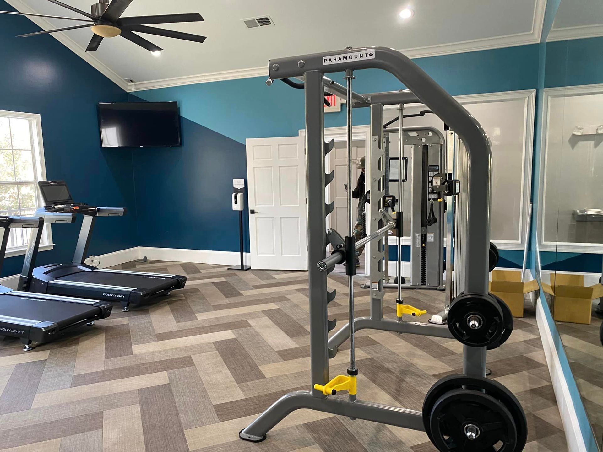 A gym with treadmills and a ceiling fan.
