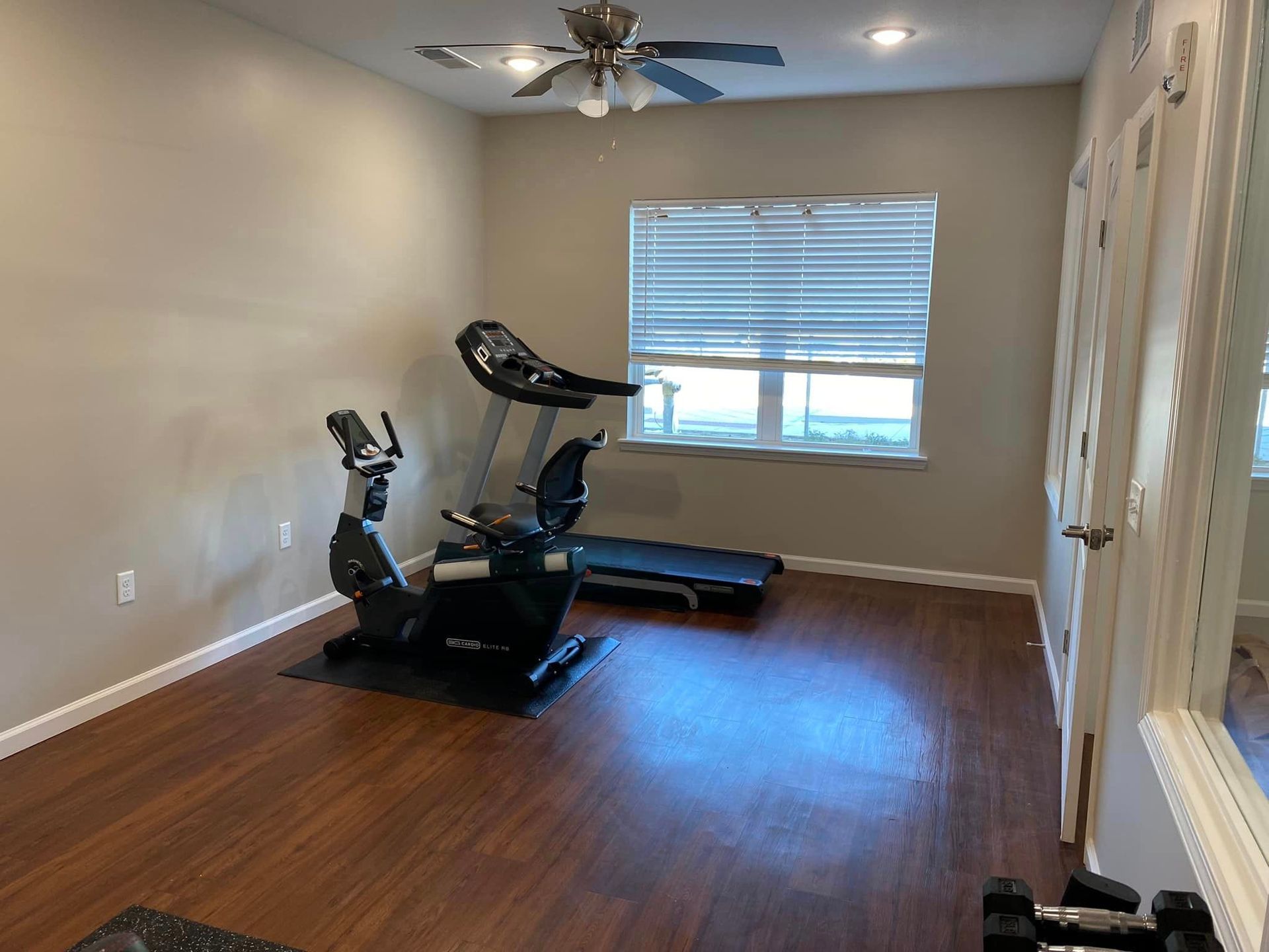 There is a treadmill and an exercise bike in the room.