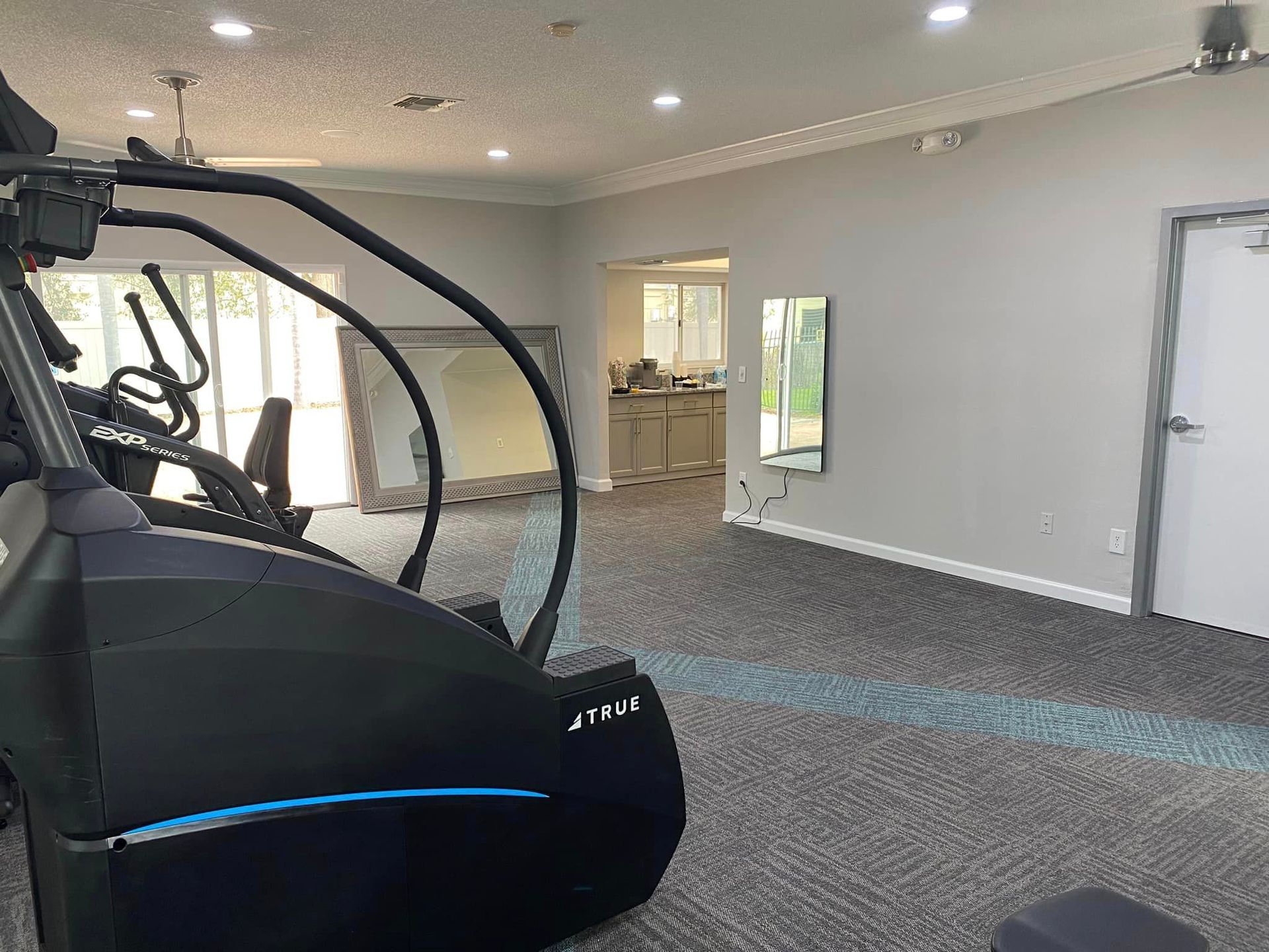 There is a elliptical machine in the middle of the room.