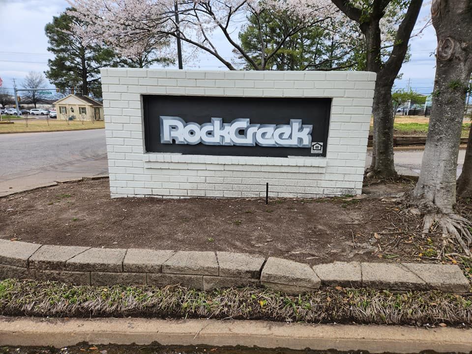 A white brick sign that says rock creek on it