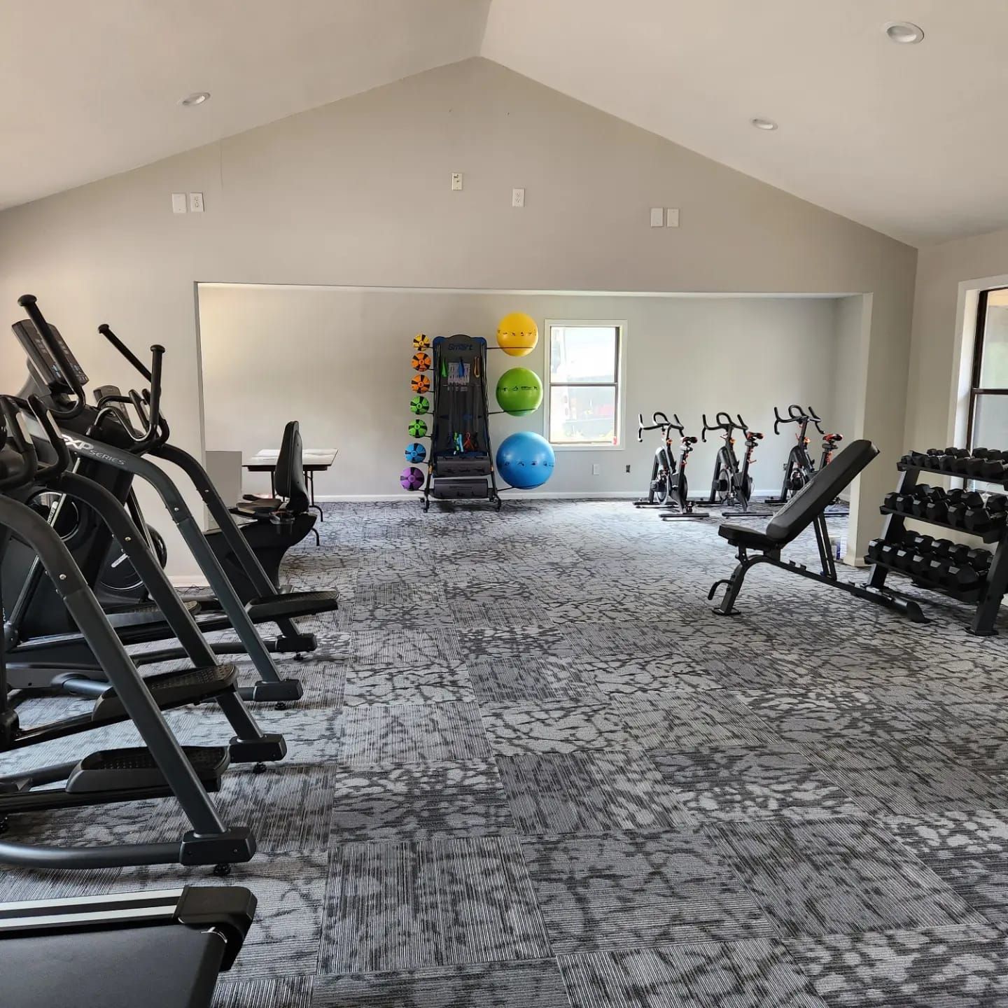 A gym with a lot of exercise equipment and a large mirror.
