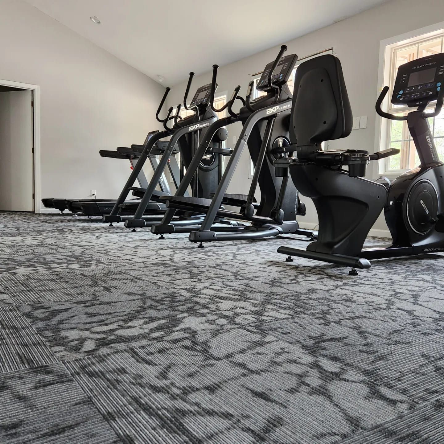 A row of treadmills and exercise bikes in a gym.