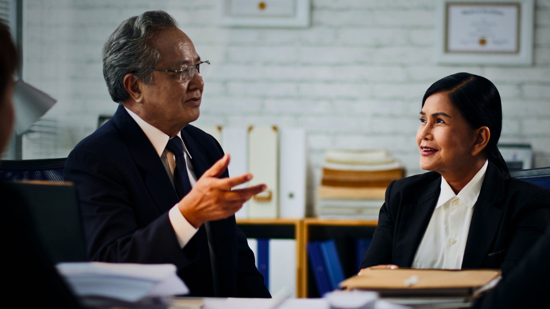 A man and a woman are sitting at a table having a conversation.