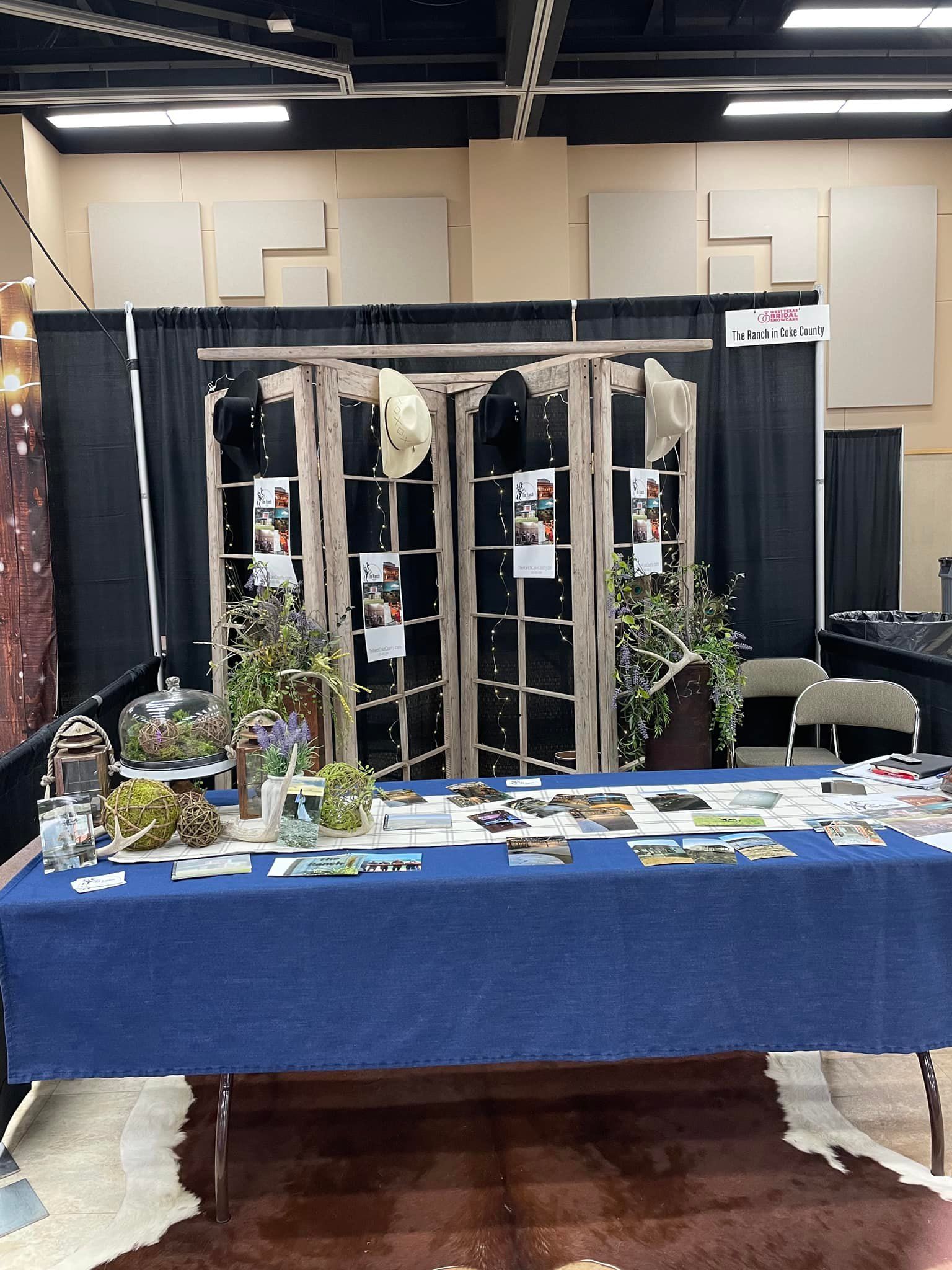 A table with a blue table cloth is sitting in a room.