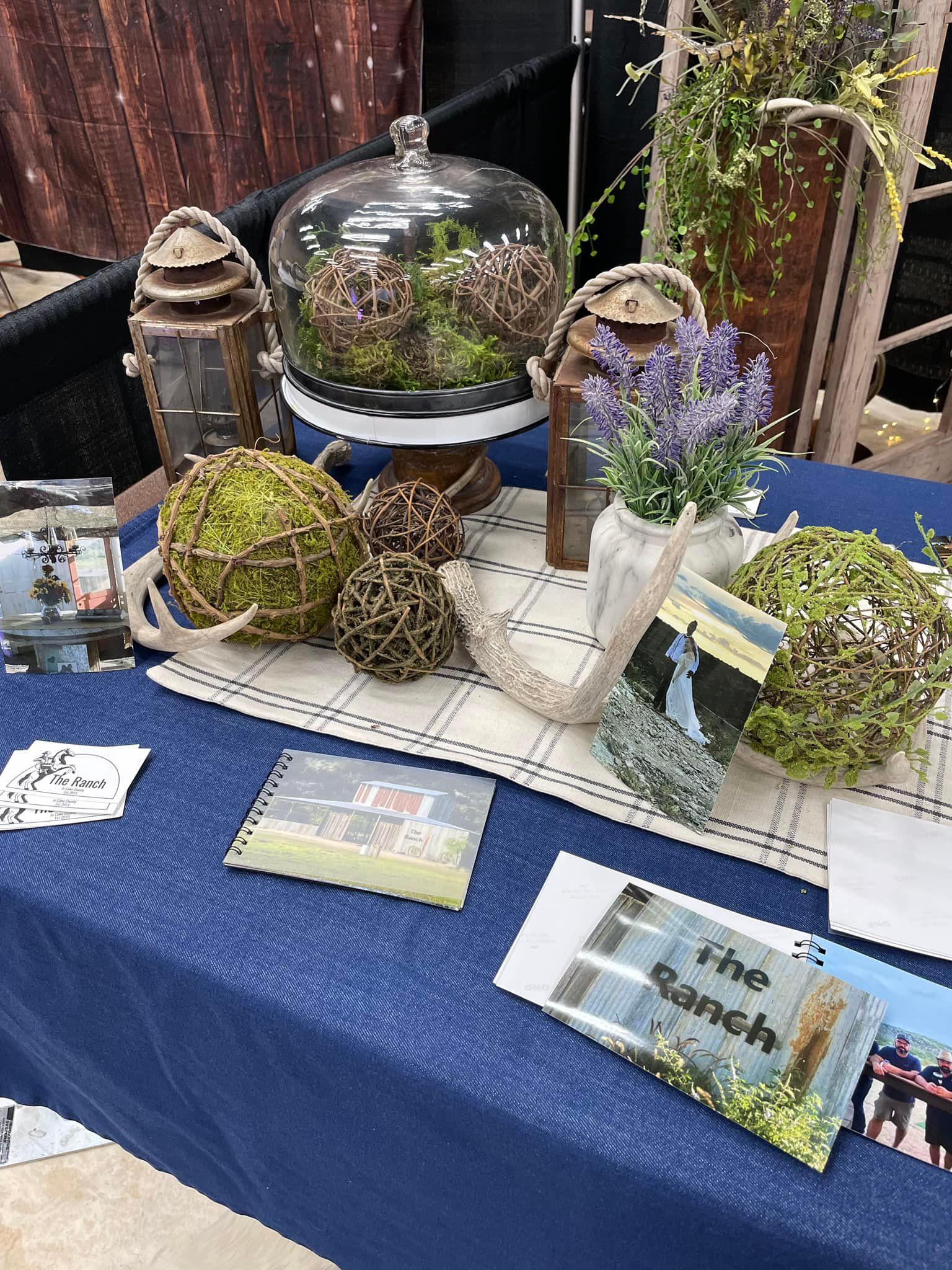 A table with a blue table cloth and a variety of decorations on it.