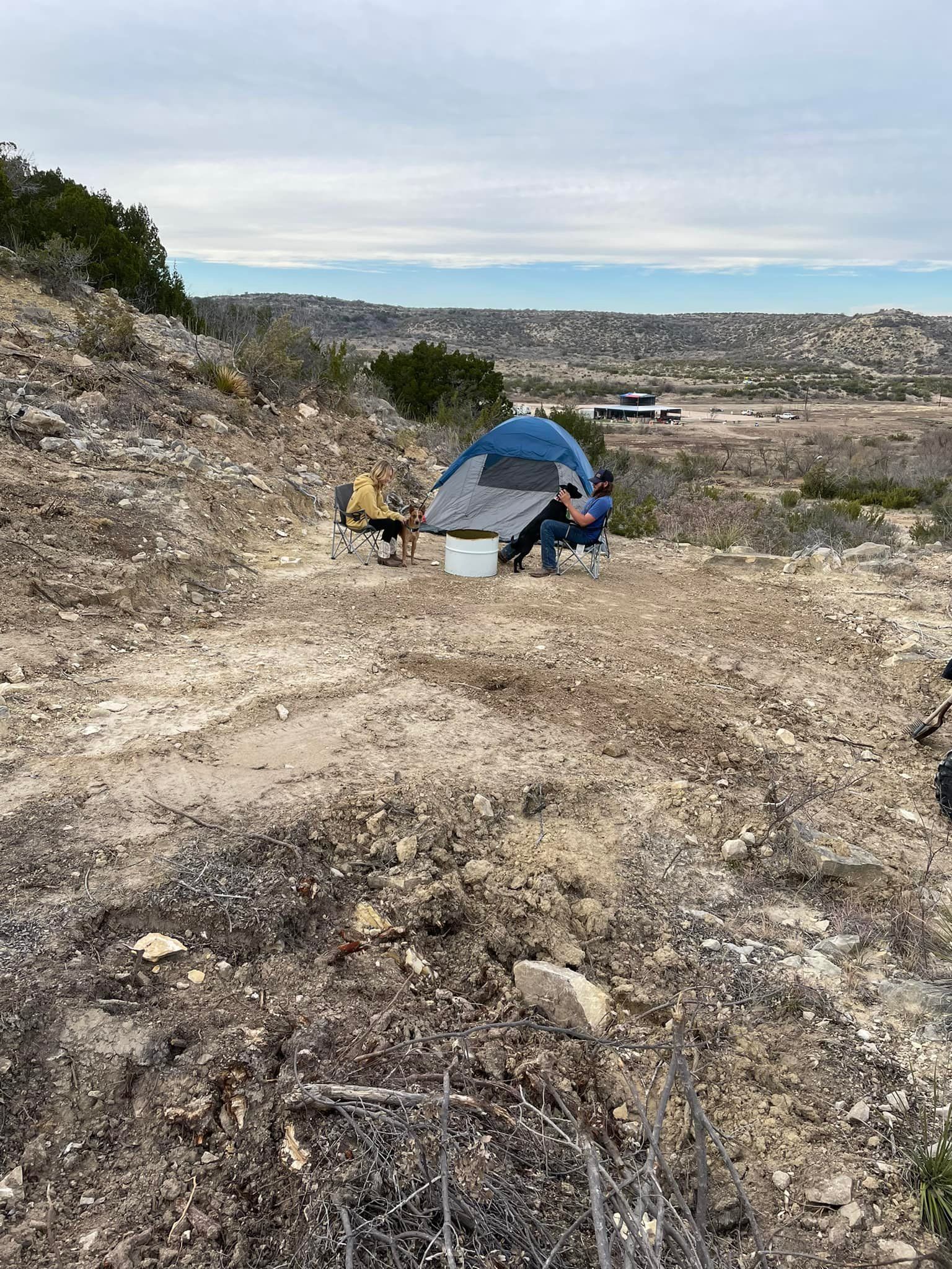 A tent is sitting on top of a dirt hill.