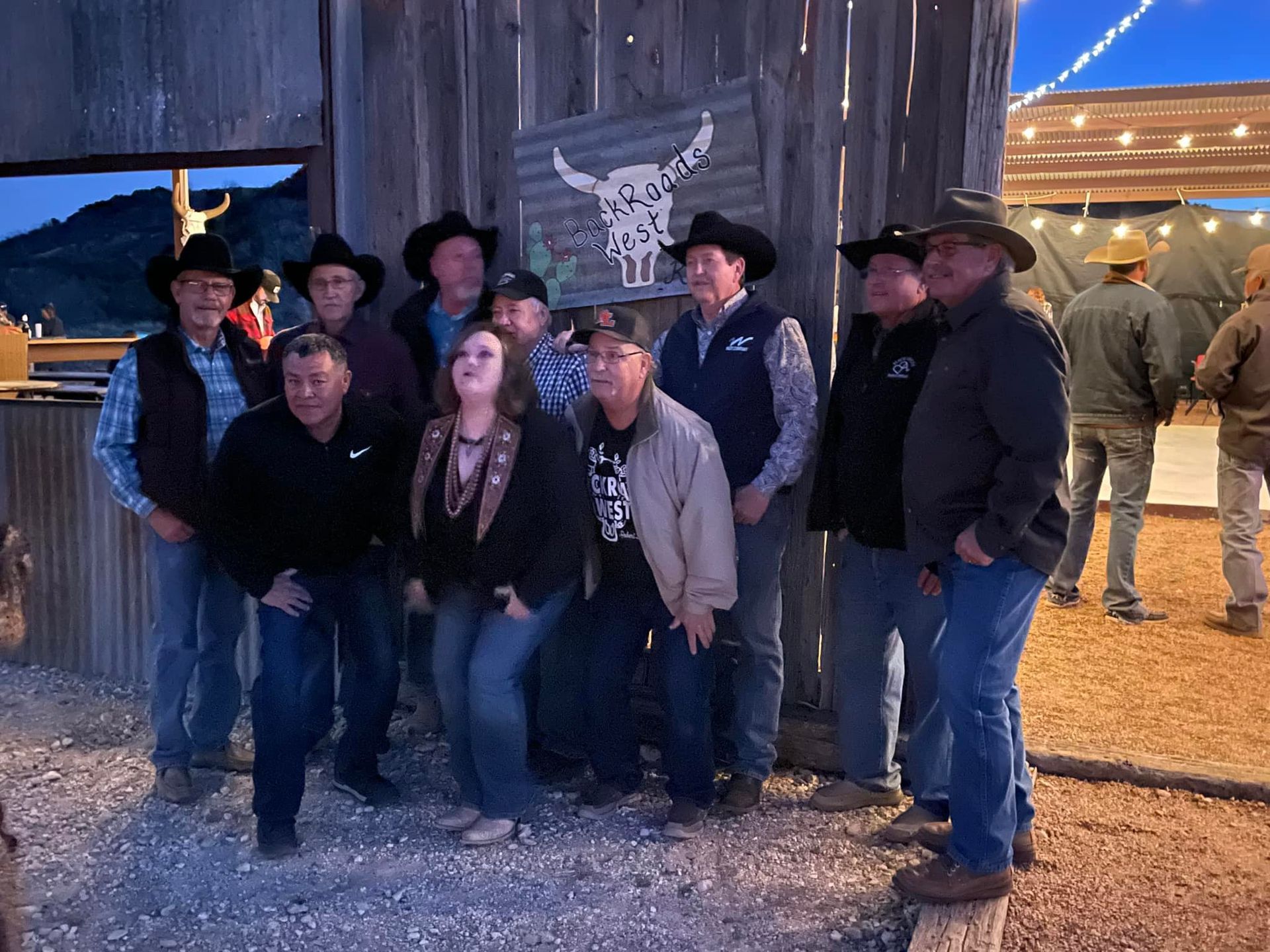 A group of people in cowboy hats are posing for a picture