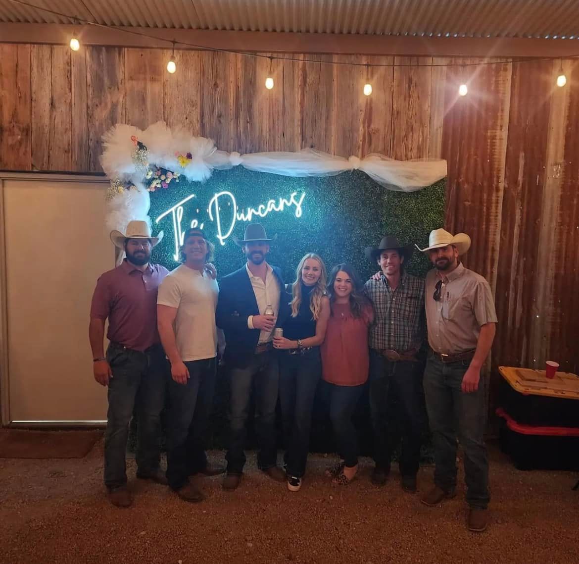 A group of people standing in front of a sign that says t. duncans