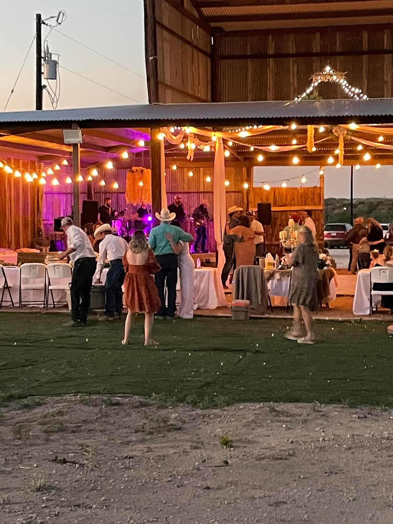 A group of people are standing in front of a large building at a wedding reception.