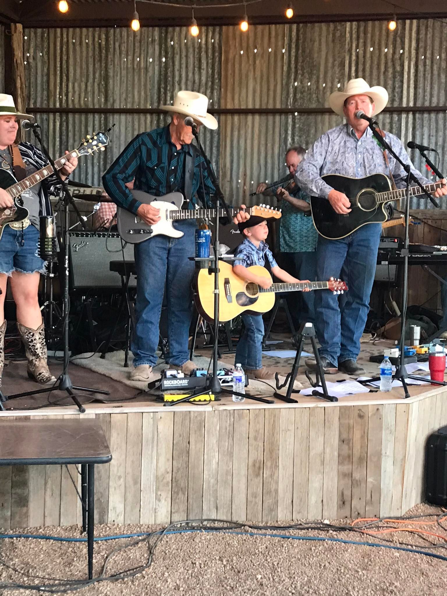 A group of people are playing guitars and singing on a stage.