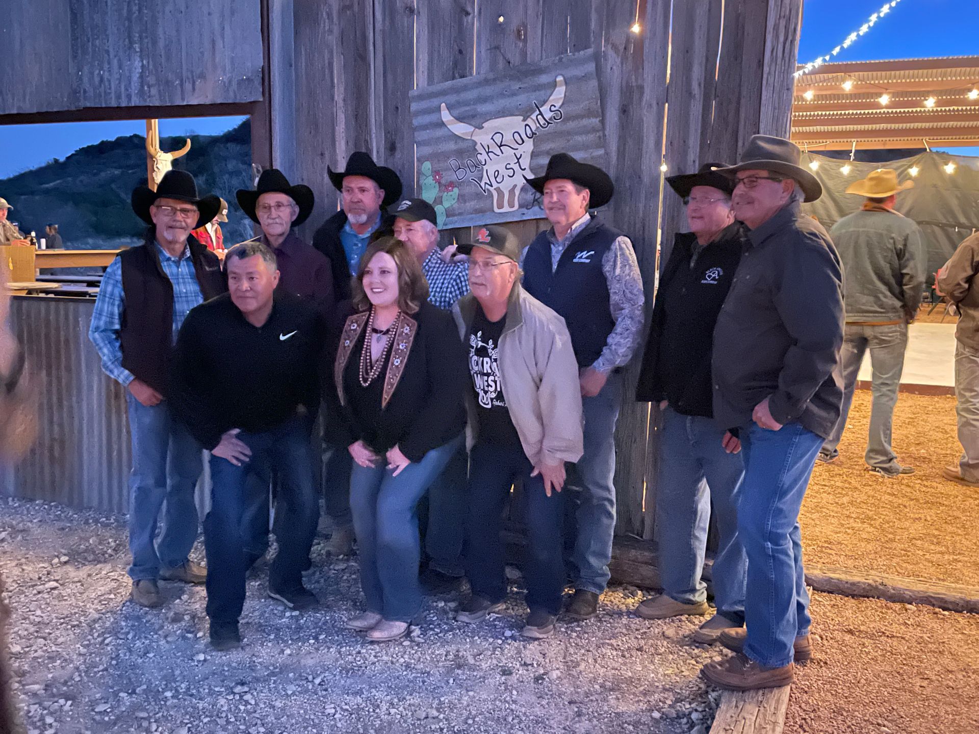 A group of people wearing cowboy hats are posing for a picture.