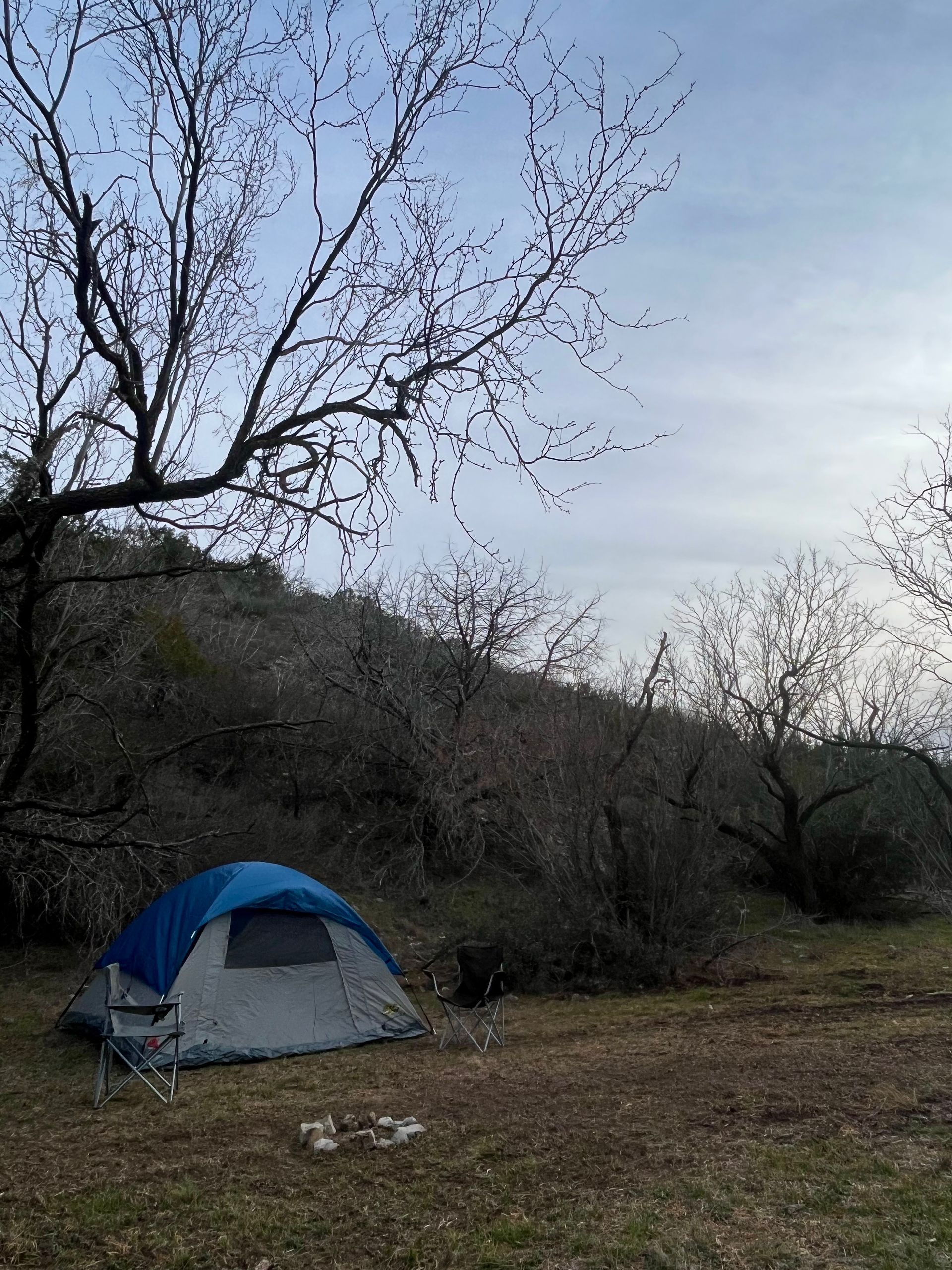 A blue tent is sitting in the middle of a field