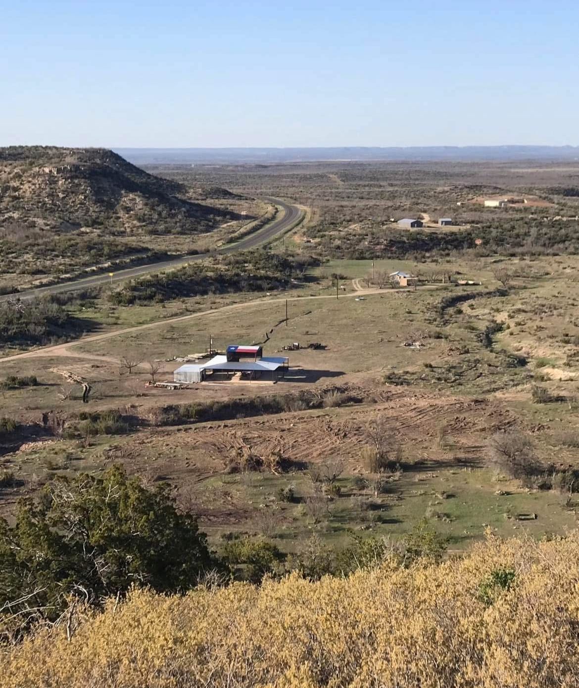 A view of a valley with a house in the middle of it