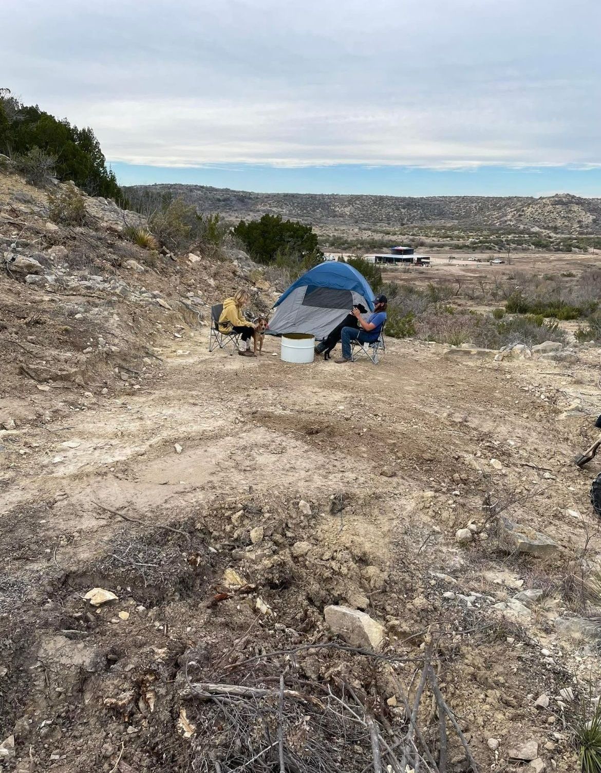 A tent is sitting on top of a dirt hill.