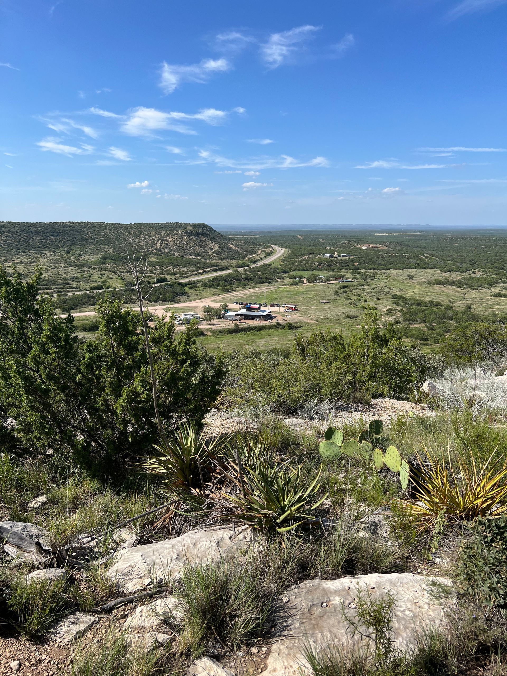 A view of a valley from the top of a hill on a sunny day.