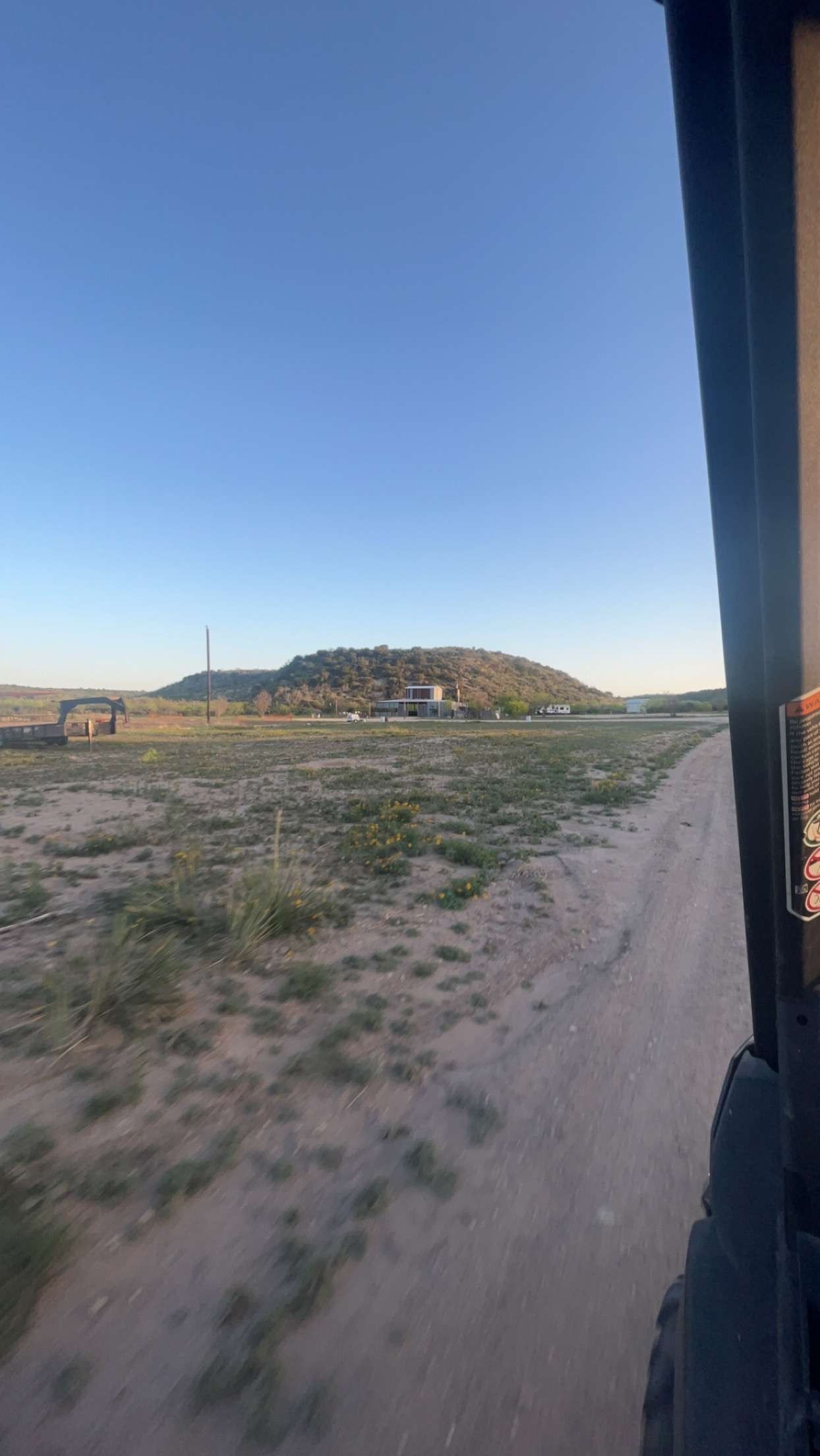A view of a dirt road from a train window.