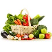 Basket overflowing with colorful vegetables and fruits, including peppers, broccoli, apples, and lettuce.