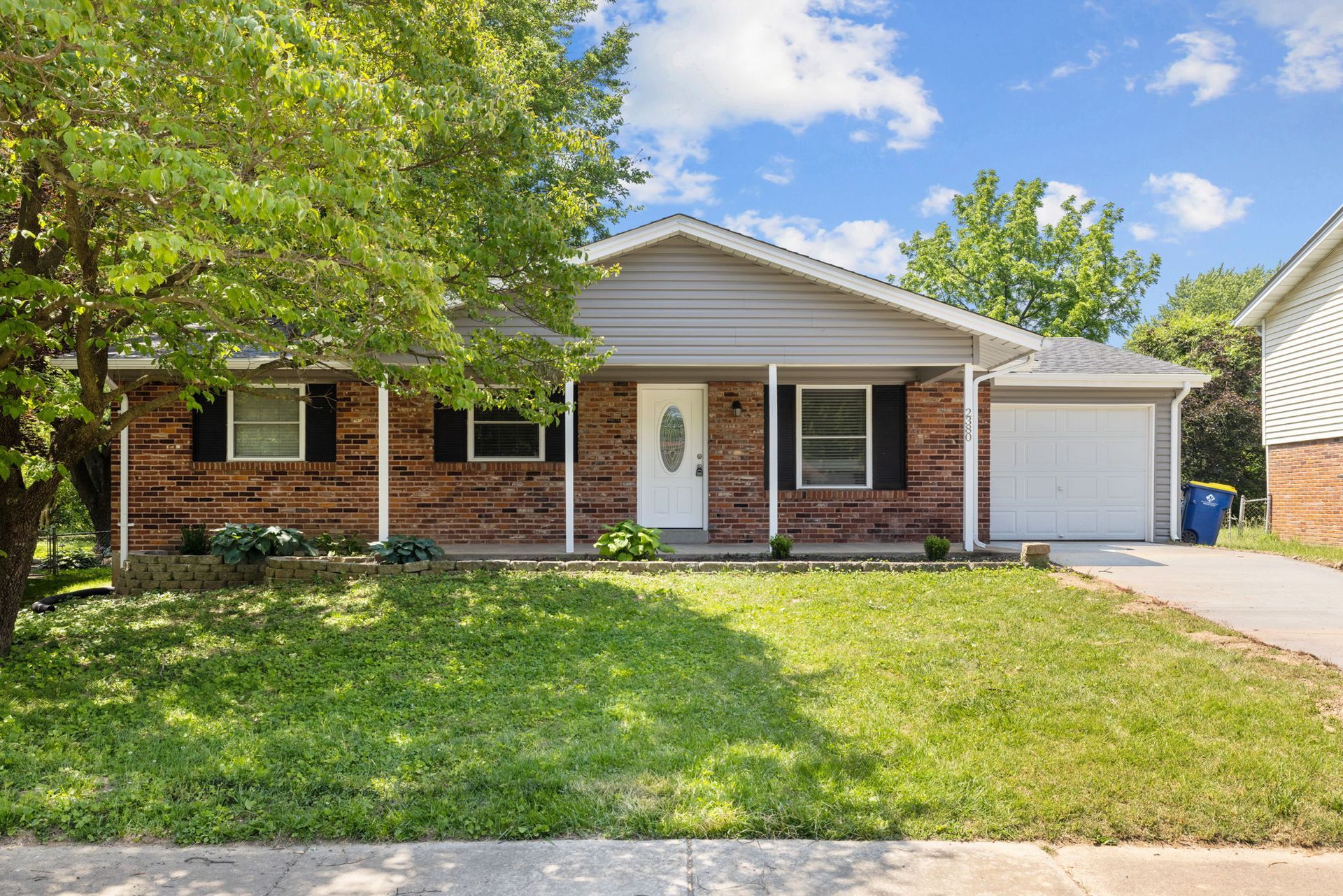 A backyard with a stone patio and a wooden fence.