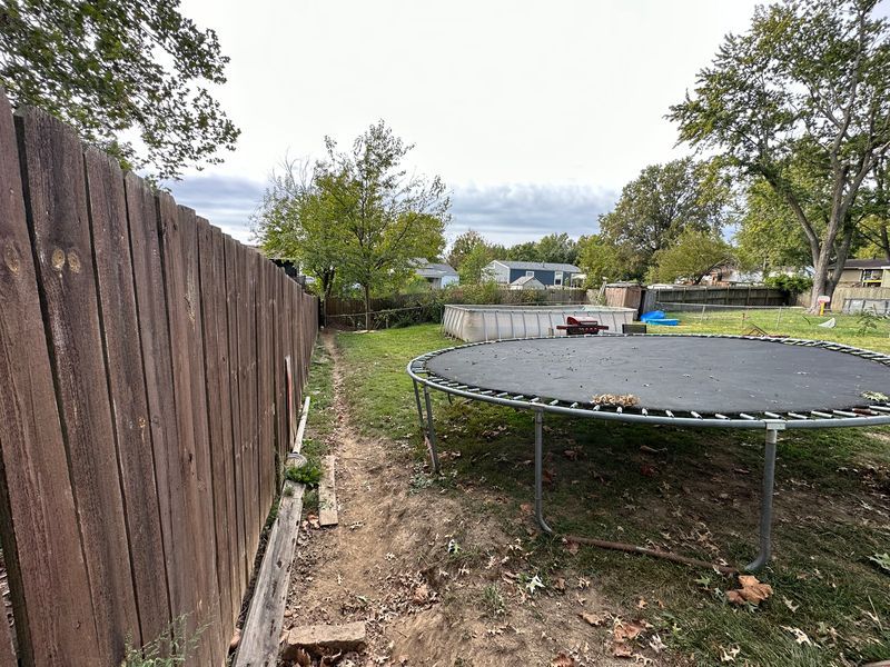 A backyard with a large swimming pool and a fire pit.