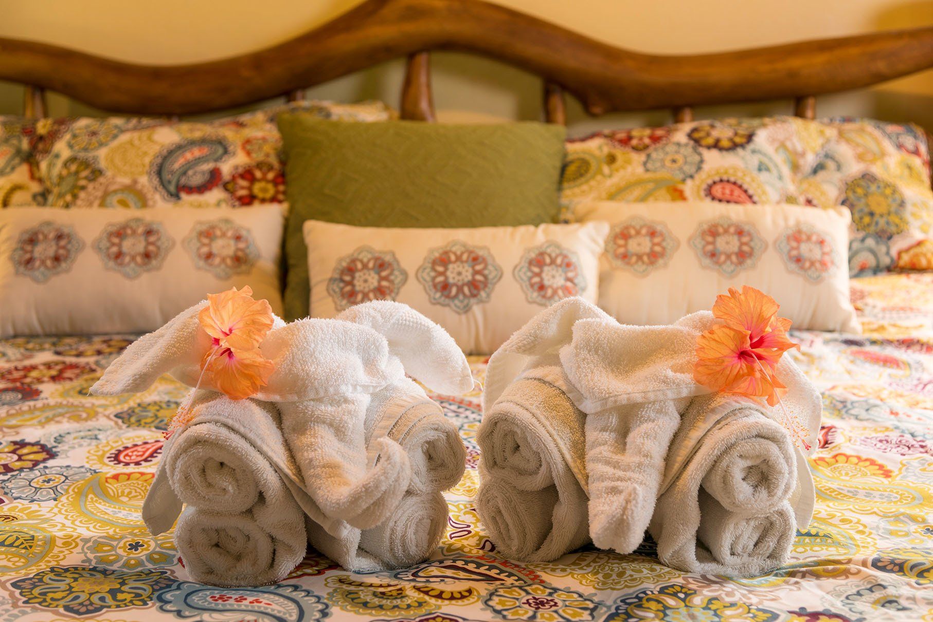 two towels are sitting on a bed with flowers on them .