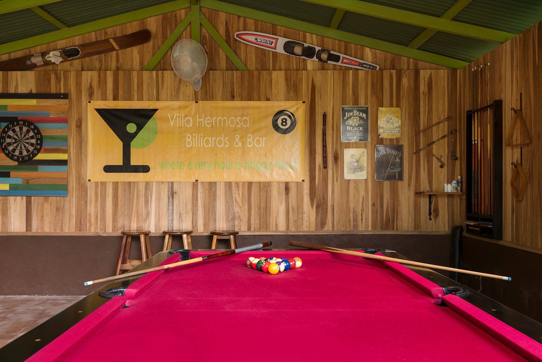 a pool table in a room with a sign on the wall .