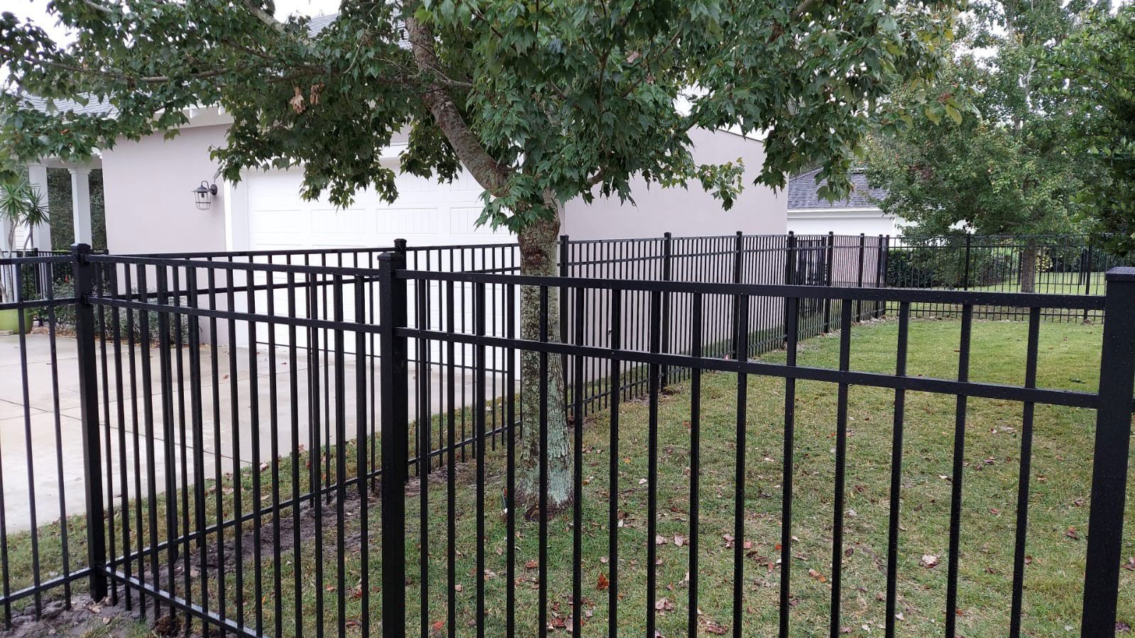 There is a black fence in front of a house.