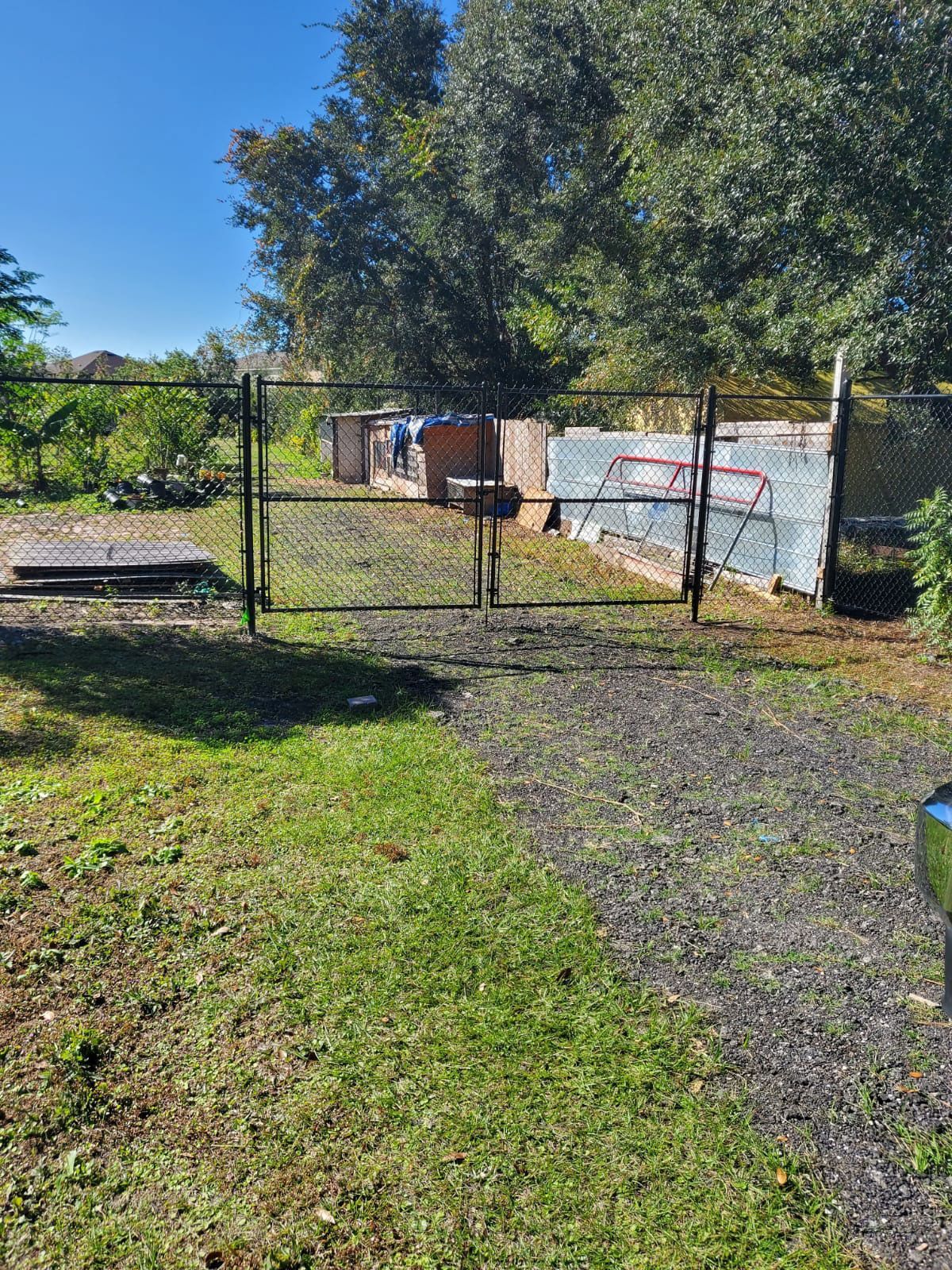 A metal gate is sitting in the middle of a grassy field.