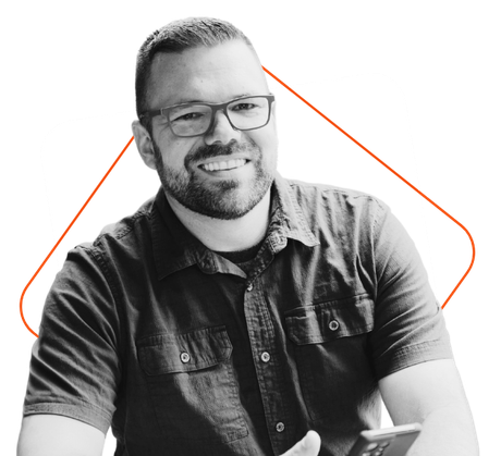 A man with a beard and glasses is sitting on a couch.