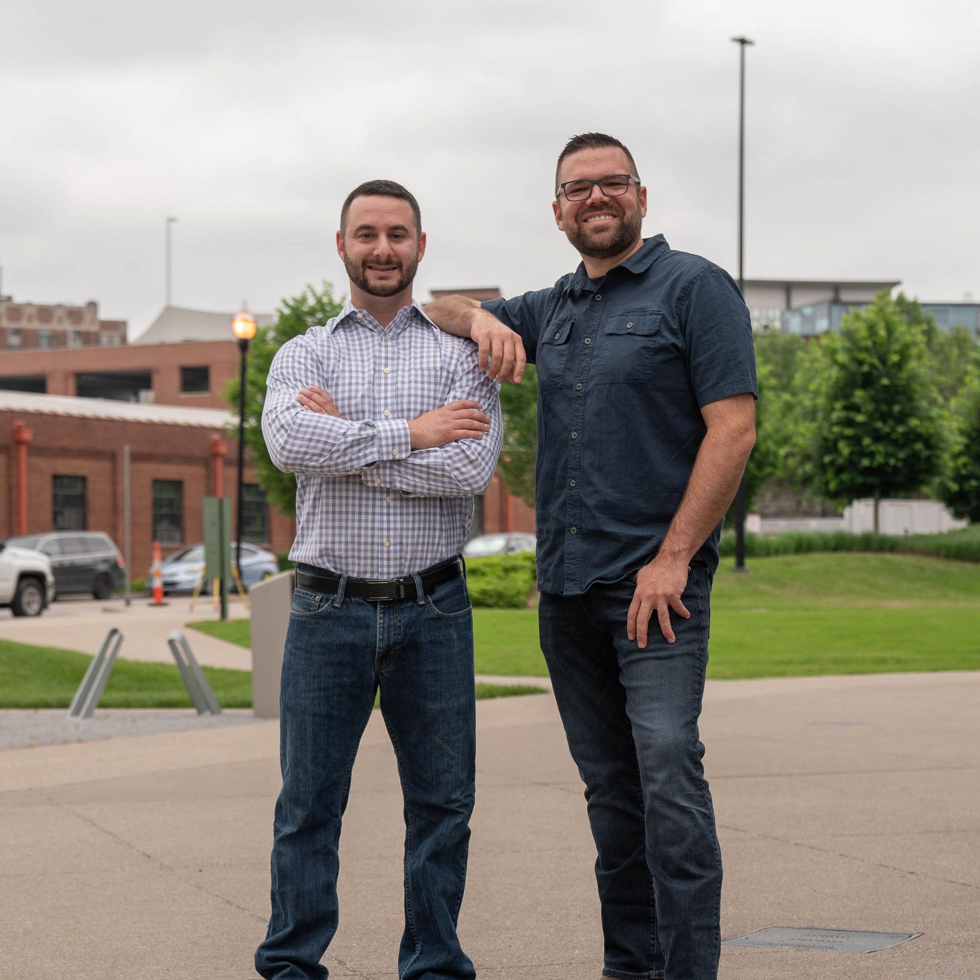 Two men standing next to each other with their arms crossed