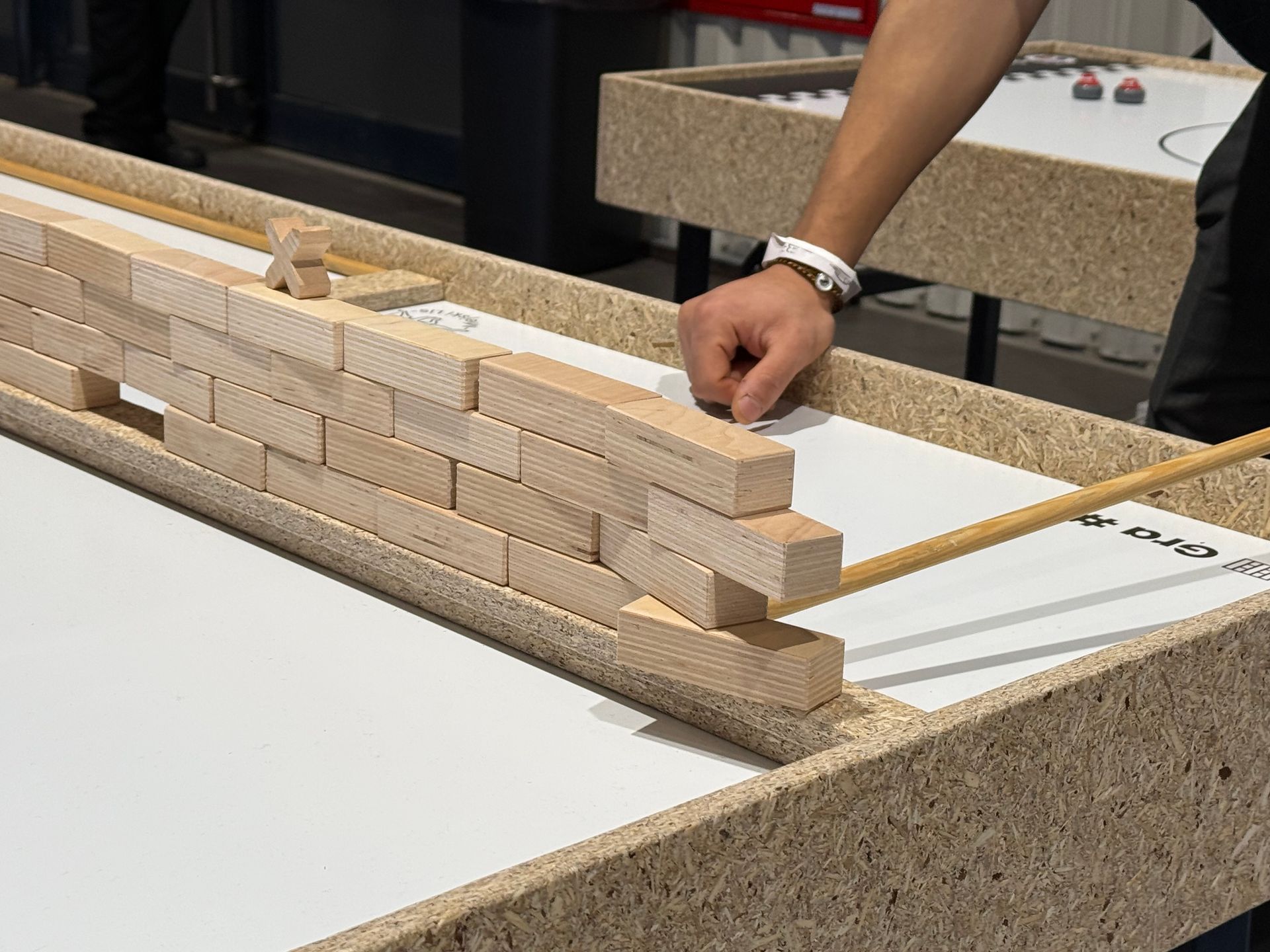 Osoba kładzie drewniane klocki na stole