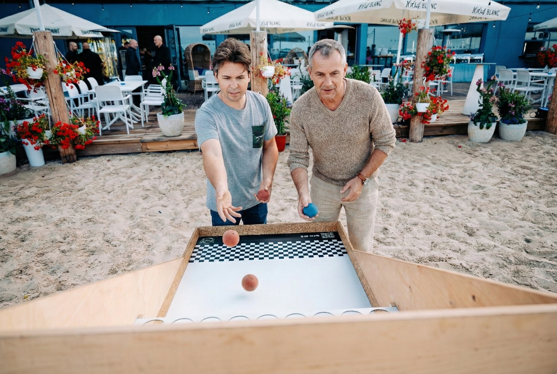 Dwie osoby grają w grę drewnianymi klockami na stole