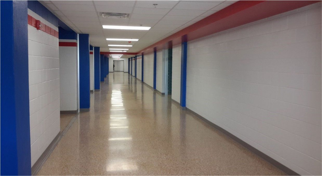 A long hallway with red , white and blue walls and columns.