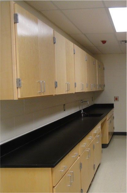 A kitchen with wooden cabinets and black counter tops