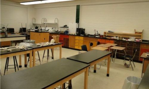 A classroom with a lot of tables and chairs