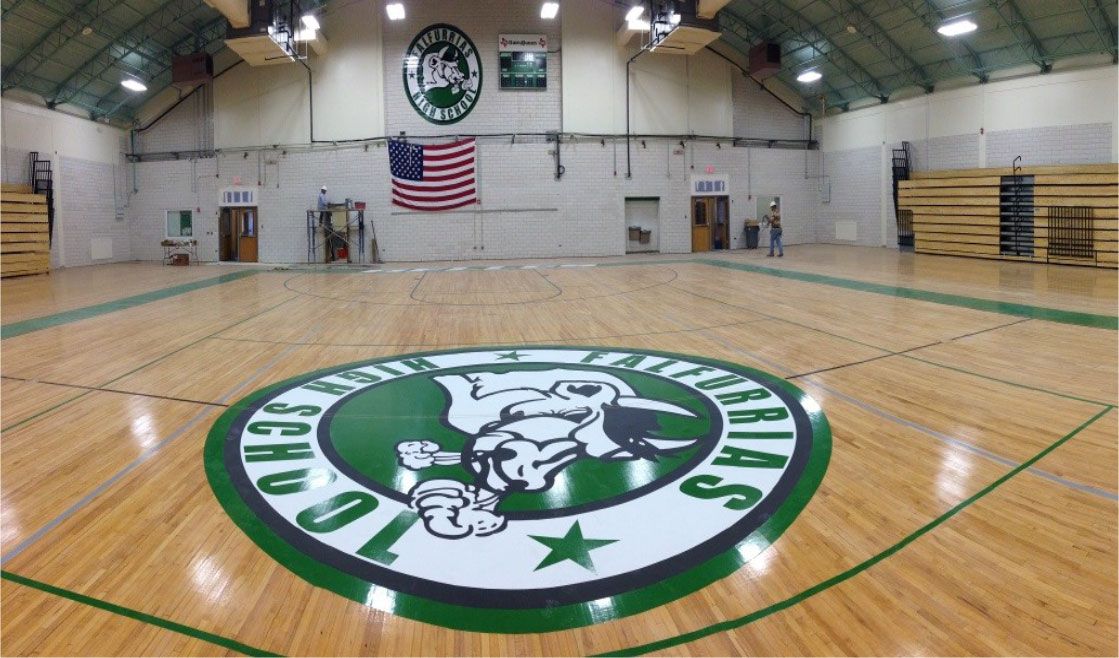 A gym with a logo on the floor that says rhode island
