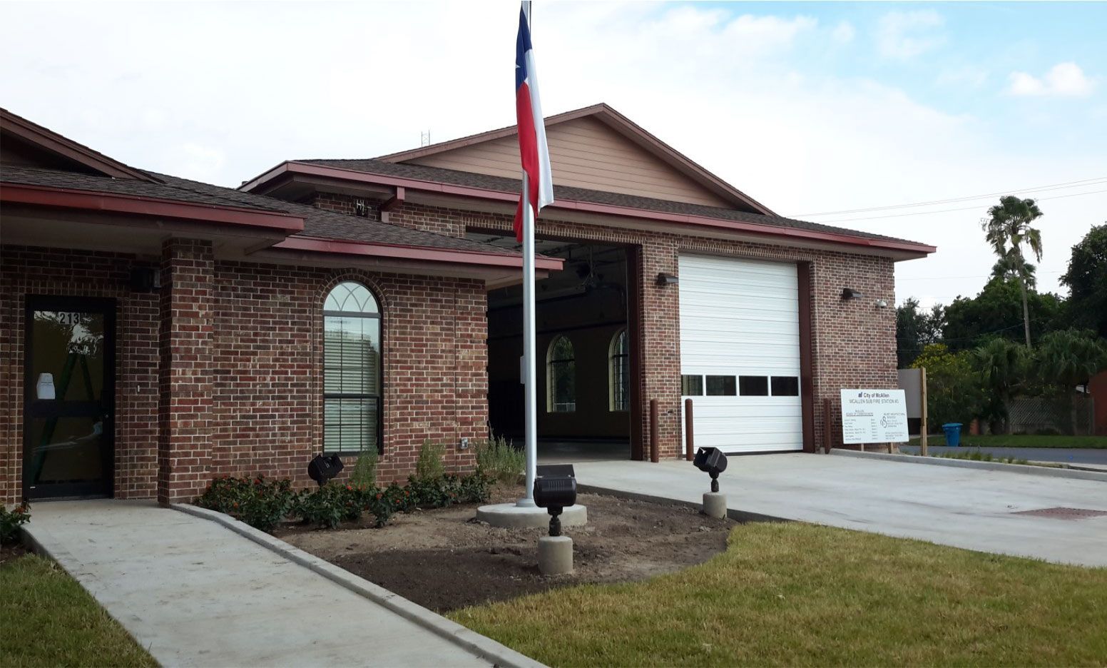 A flag is flying in front of a brick building.