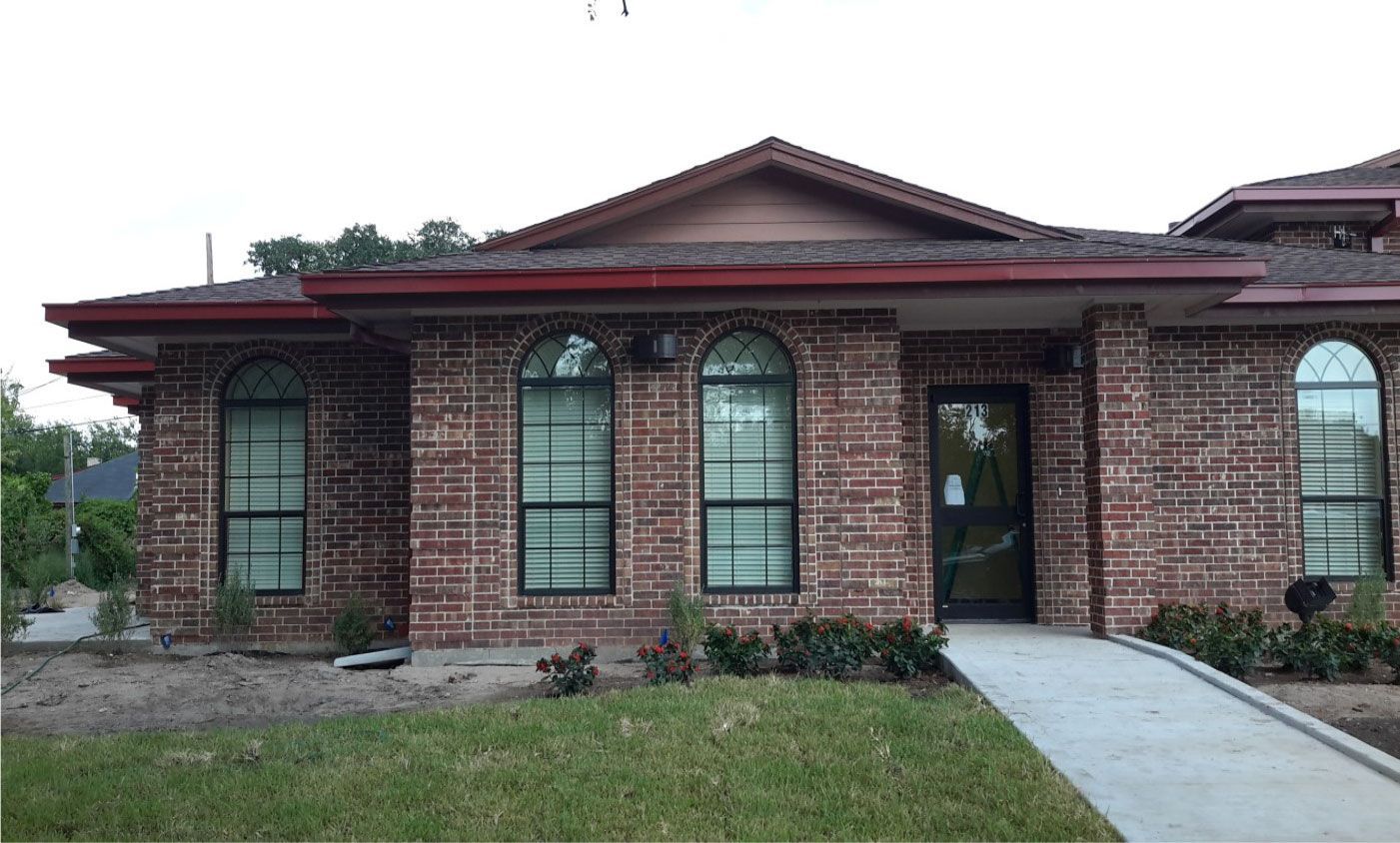 A brick house with a ramp leading to the front door.