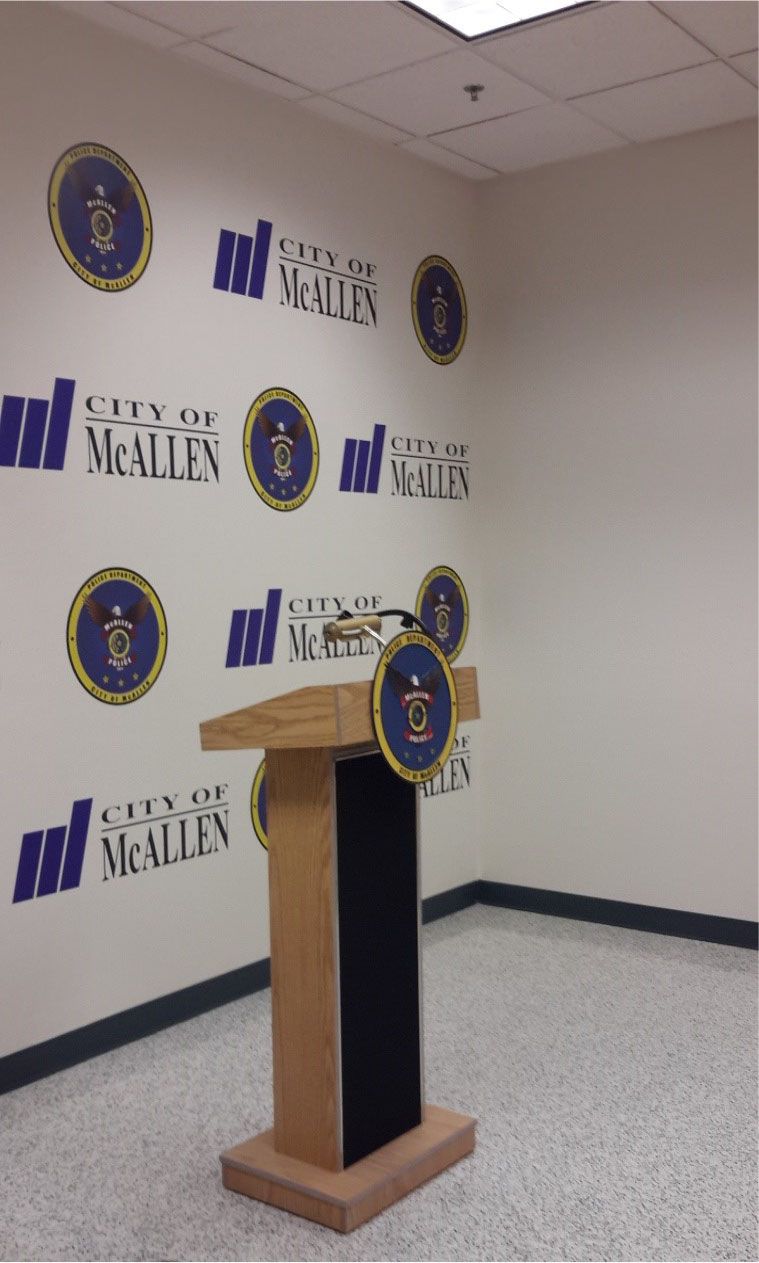 A podium in front of a wall that says city of mcallen