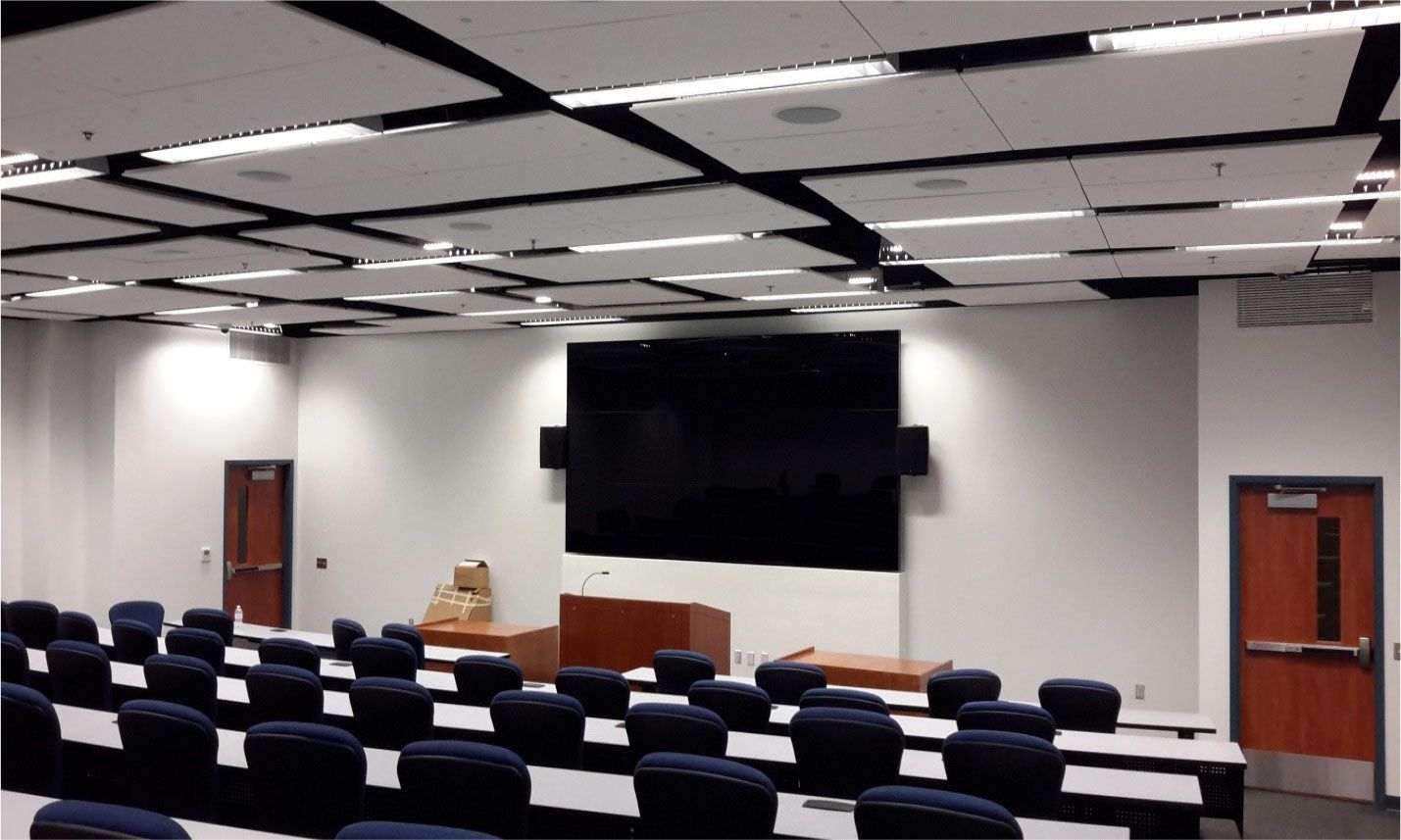 A large lecture hall with rows of tables and chairs