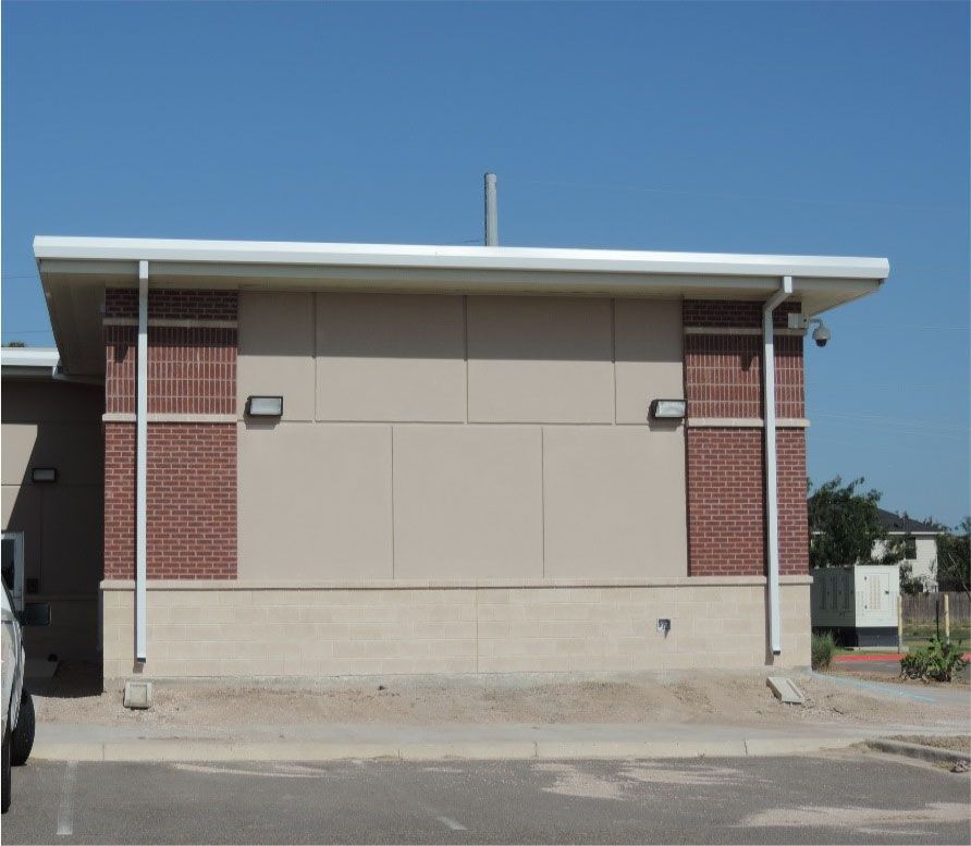 A small brick building with a white roof