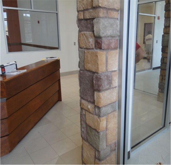 A room with a wooden desk and a stone pillar