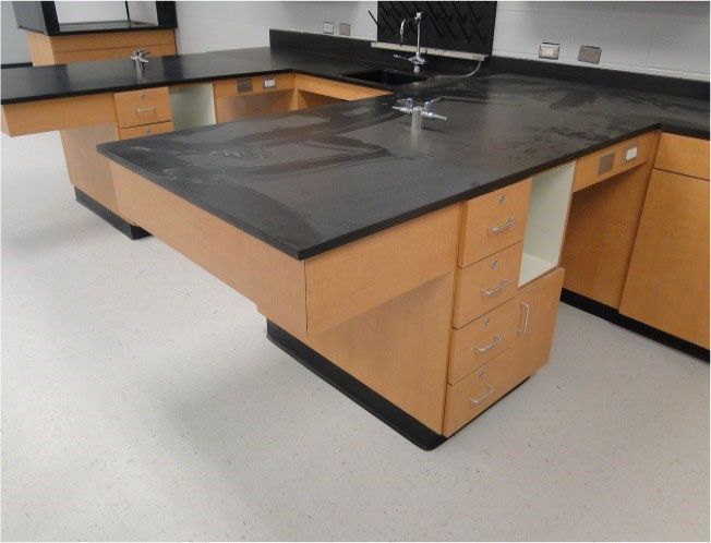 A kitchen with black counter tops and wooden cabinets